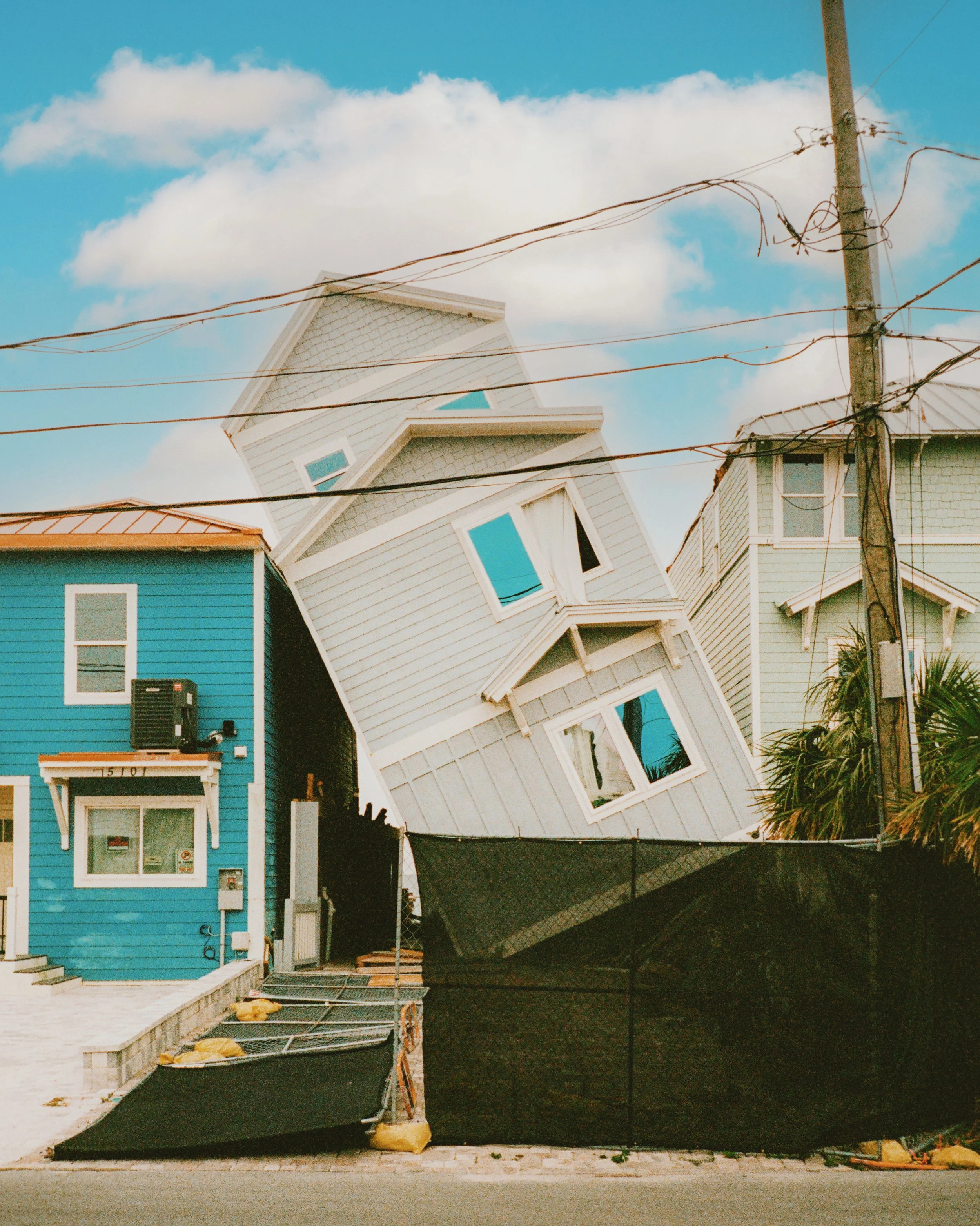 Crooked blue house leaning between neighboring houses, shot on a Leica M6