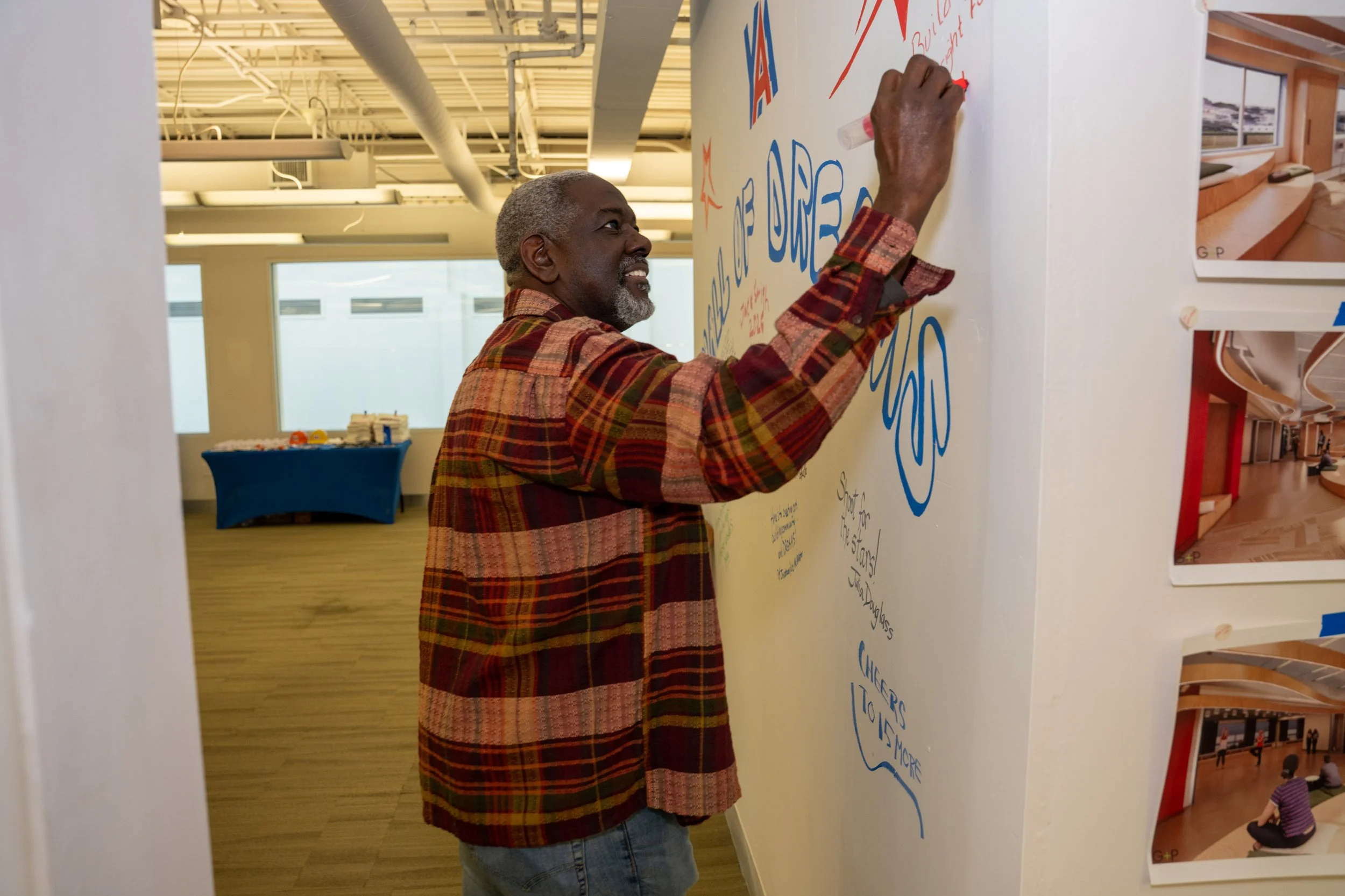 Building Dreams Campaign Chair, Ollen Douglass signs the Wall of Dreams