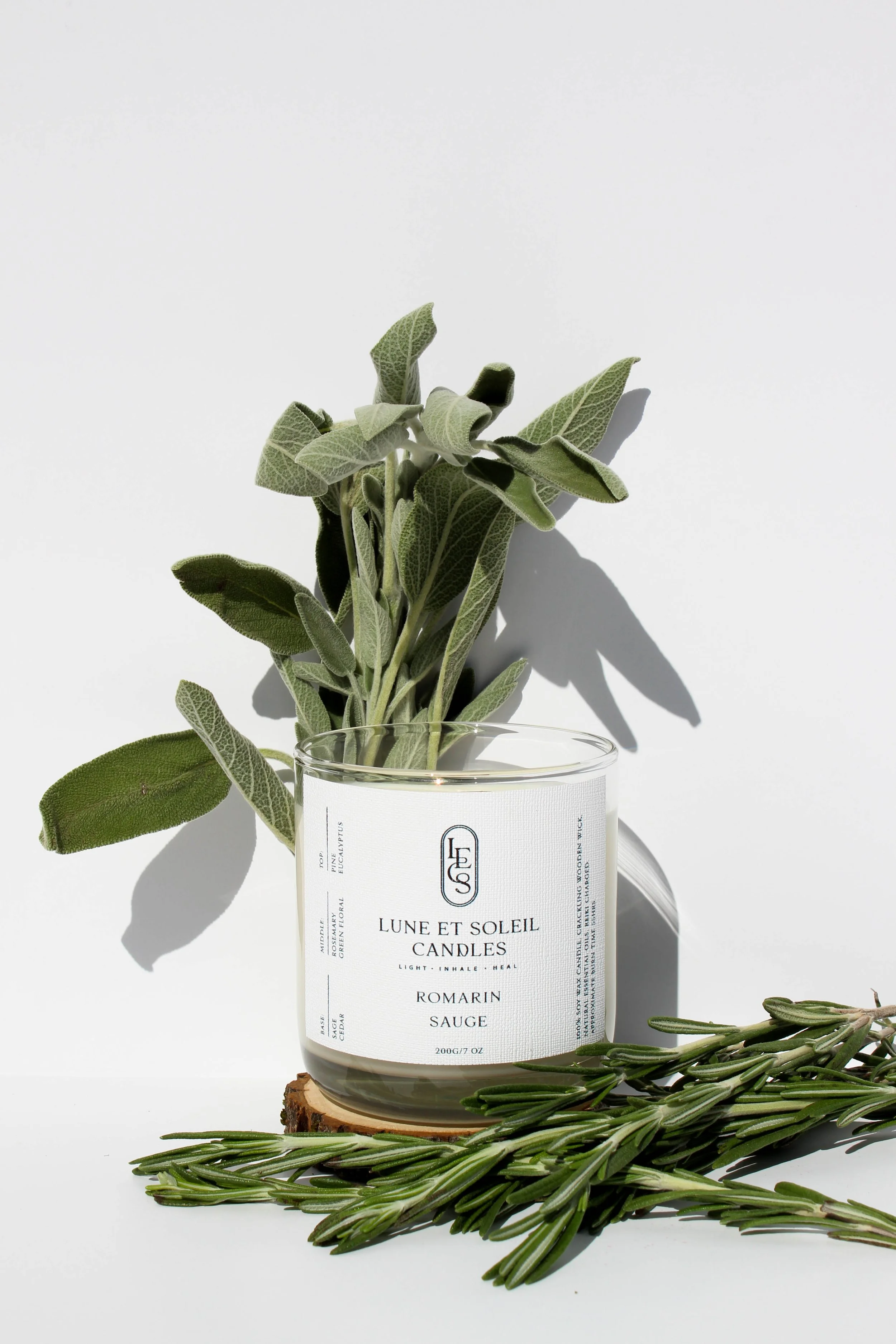 Romarin Sauge soy wax candle in a clear glass vessel styled with fresh sage and rosemary by Lune et Soleil