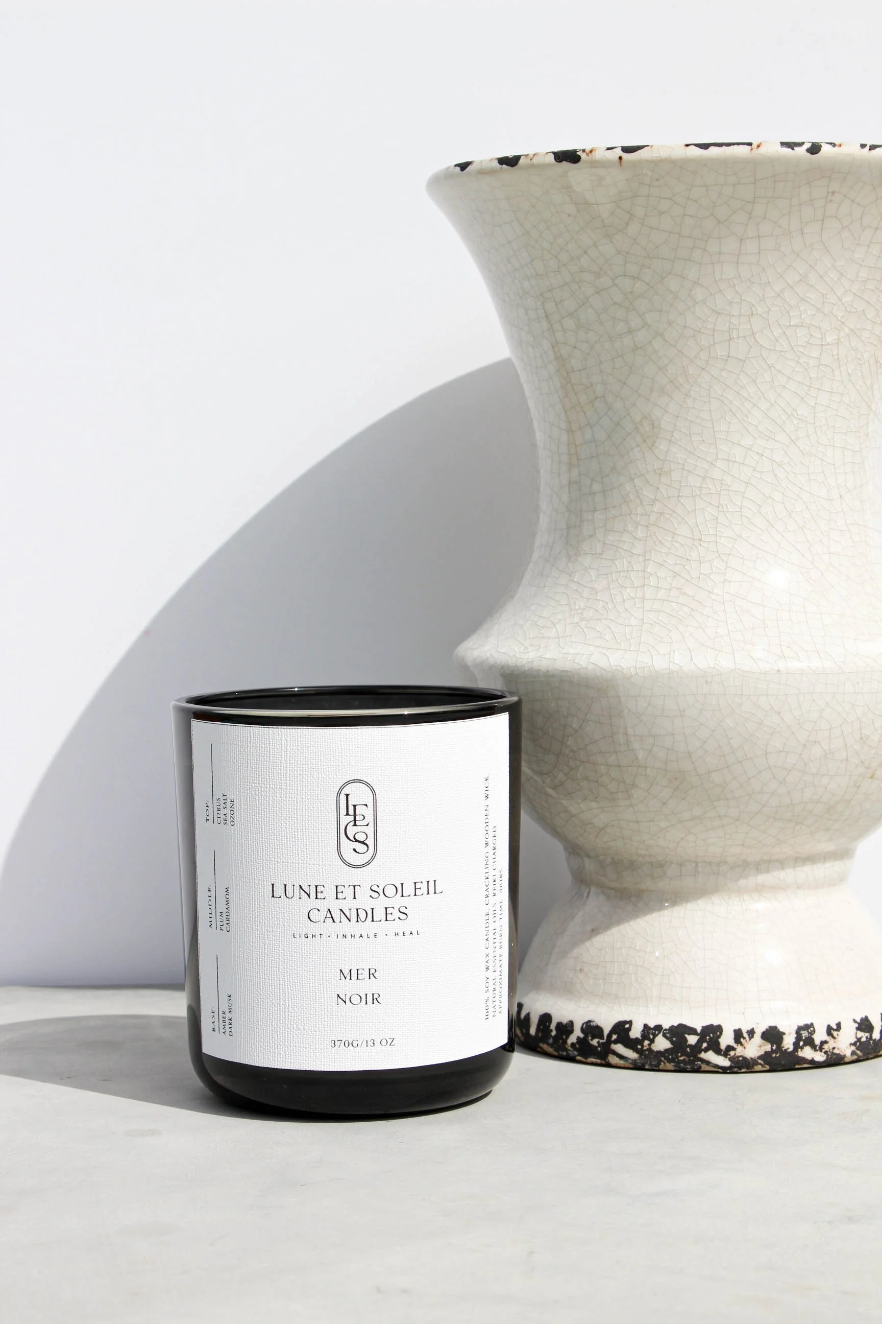 Mer Noir soy candle in a dark vessel styled with a vase by Lune et Soleil