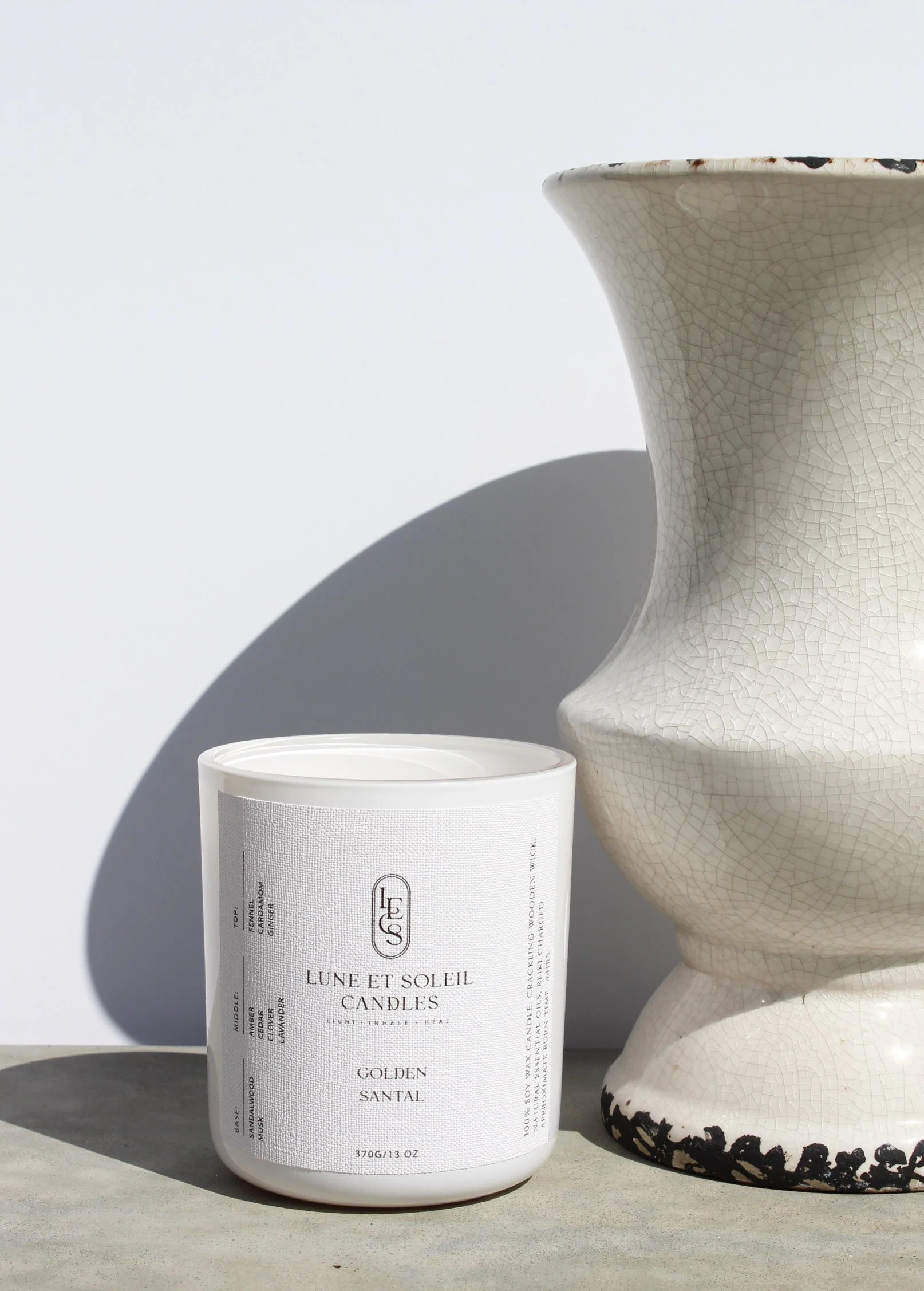 Golden Santal soy wax candle in a white vessel style with a vase by Lune et Soleil