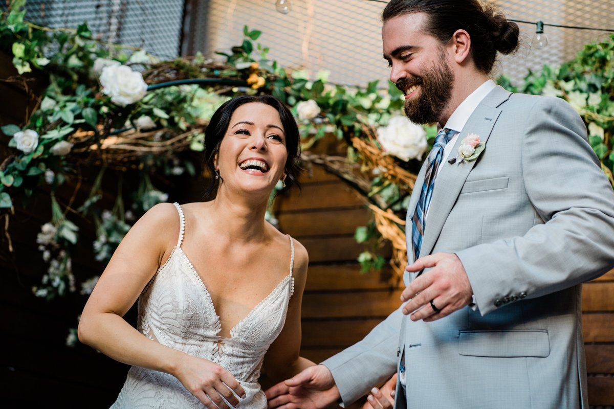Bride and groom laughing after their first dance as a married couple.
