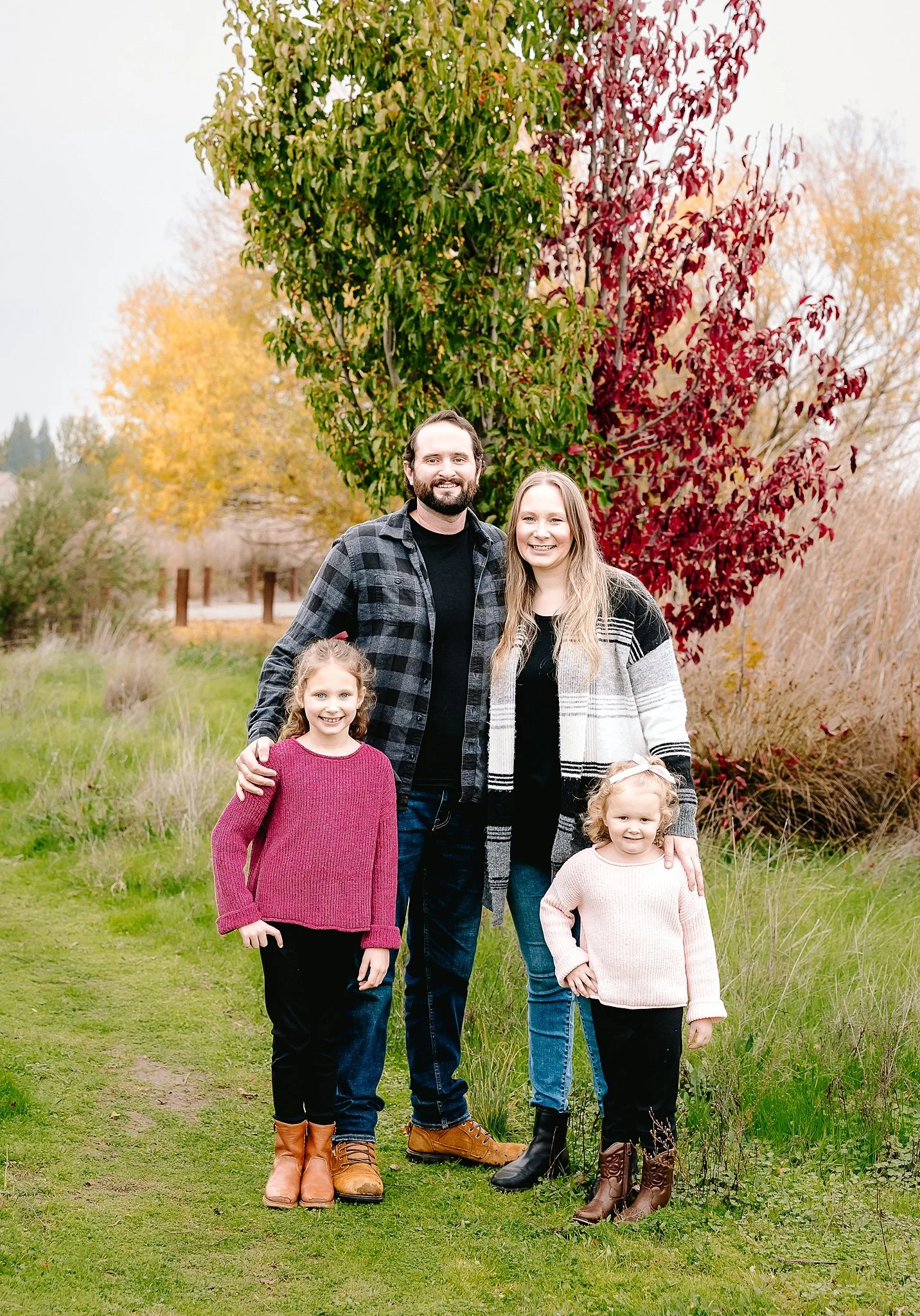Family of four standing together during an outdoor fall family portrait session in Elk Grove, California