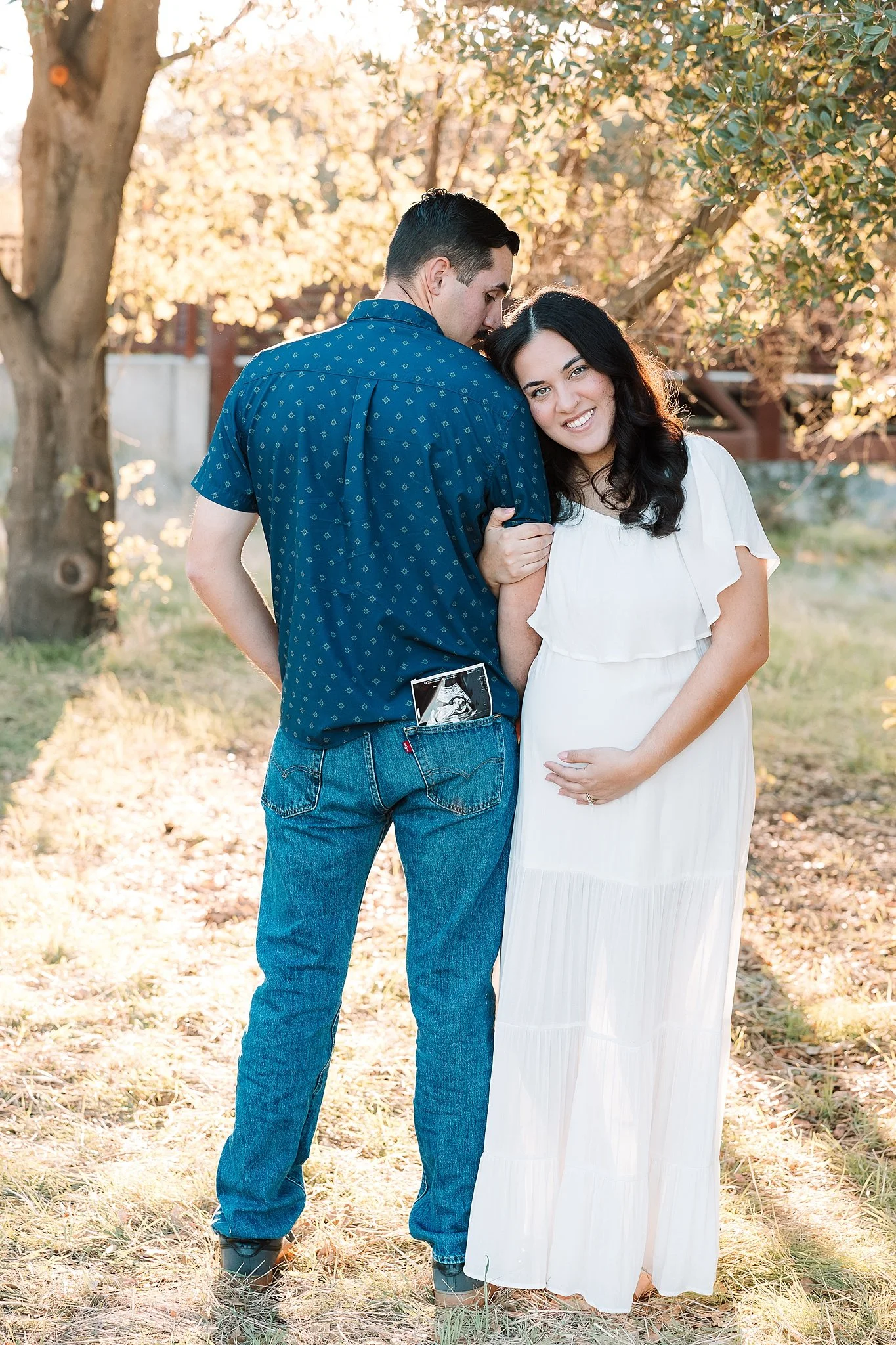 Outdoor maternity photo in Elk Grove, California of an expecting couple with an ultrasound photo tucked into dad’s pocket during their session