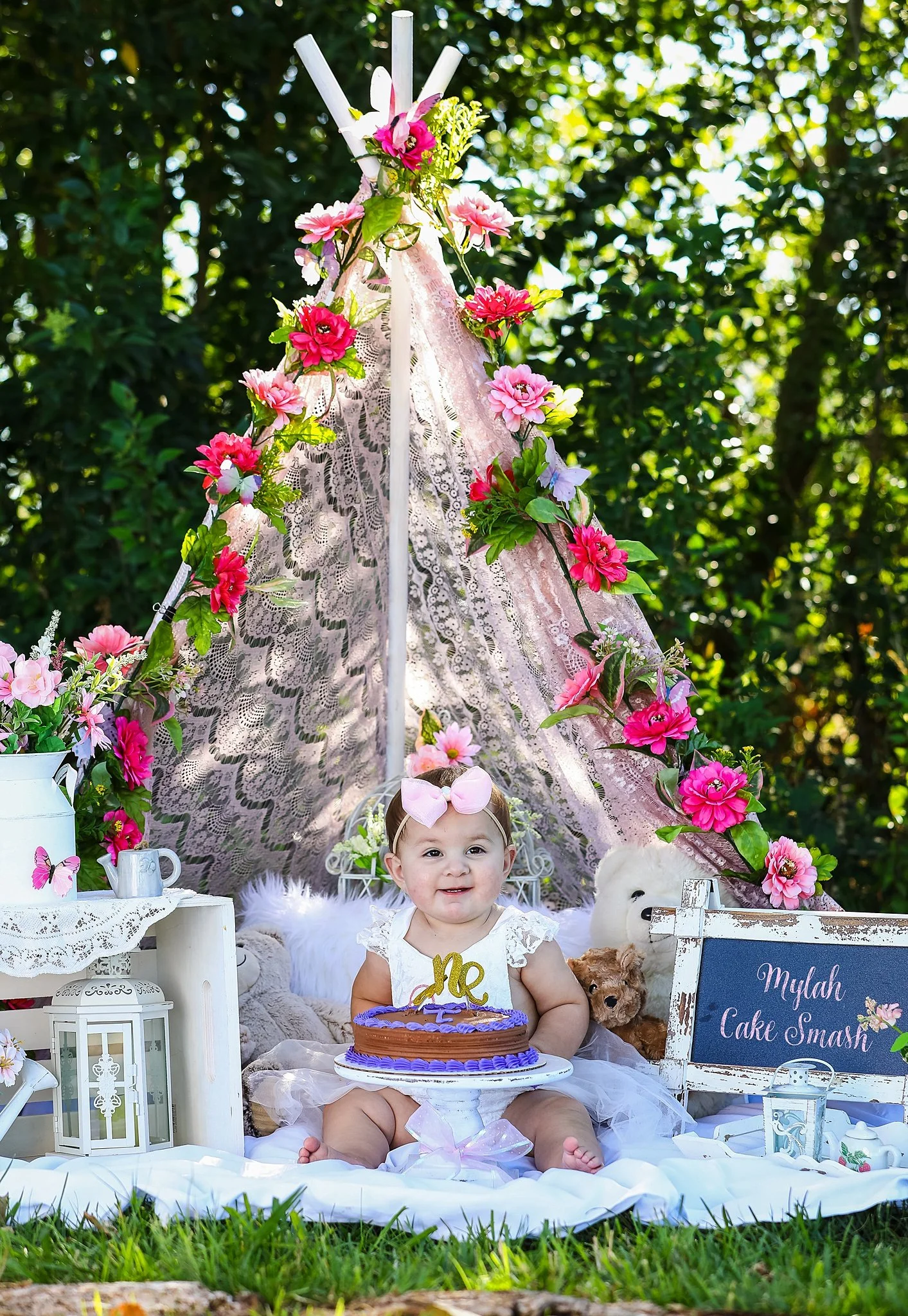 Floral themed first birthday cake smash session with lace teepee backdrop photographed during an Elk Grove milestone session.