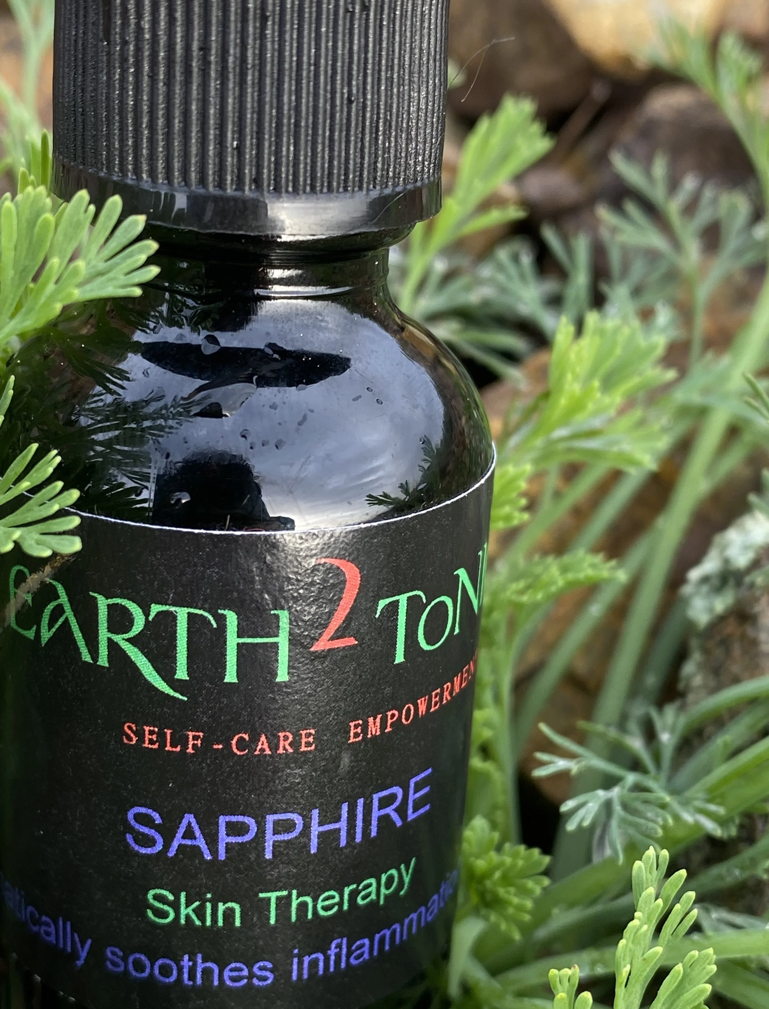 “Sapphire 1oz botanical face and hair oil by Earth2Tonics, a nutrient-rich aromatic blend that hydrates, balances, and revitalizes skin and scalp using pure essential oils.”