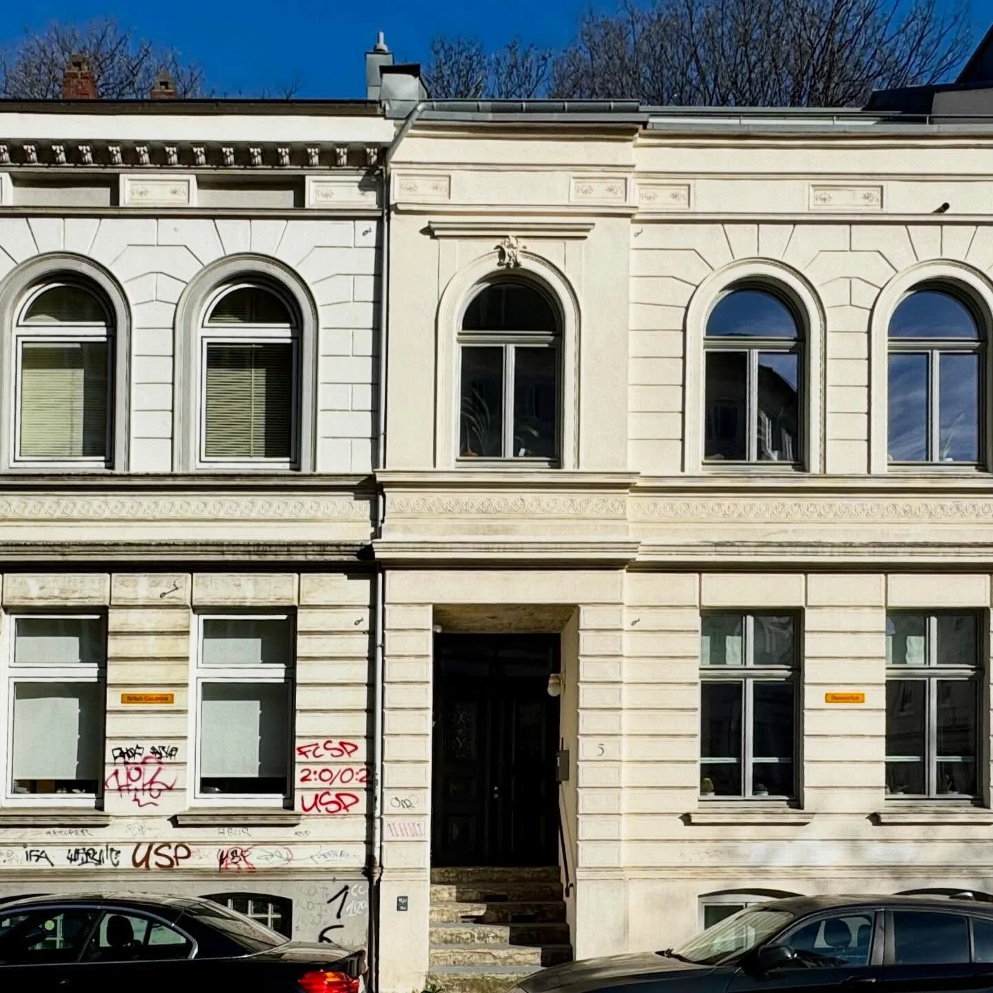 Am Lornsenplatz 5 in Altona h&auml;ngen an der Fassade zweier Stadth&auml;user zwei leuchtend gelbe Emailleschilder mit den Aufschriften &bdquo;Democritus&ldquo; und &bdquo;British Columbia&ldquo;. Anders als gew&ouml;hnliche Stra&szlig;enschilder ve