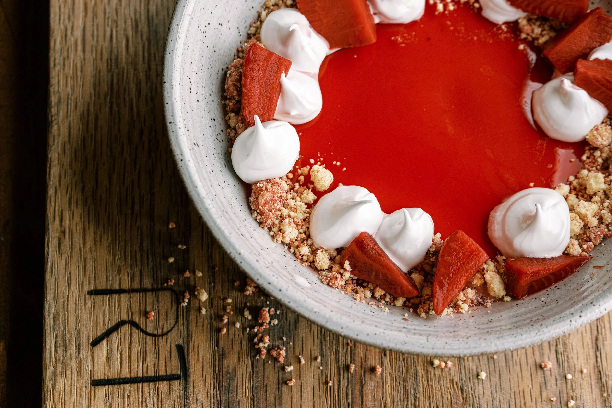 Strawberry tart with cream dollops and crumble crust on a ceramic plate, fine dining dessert food photography by Cody Myers