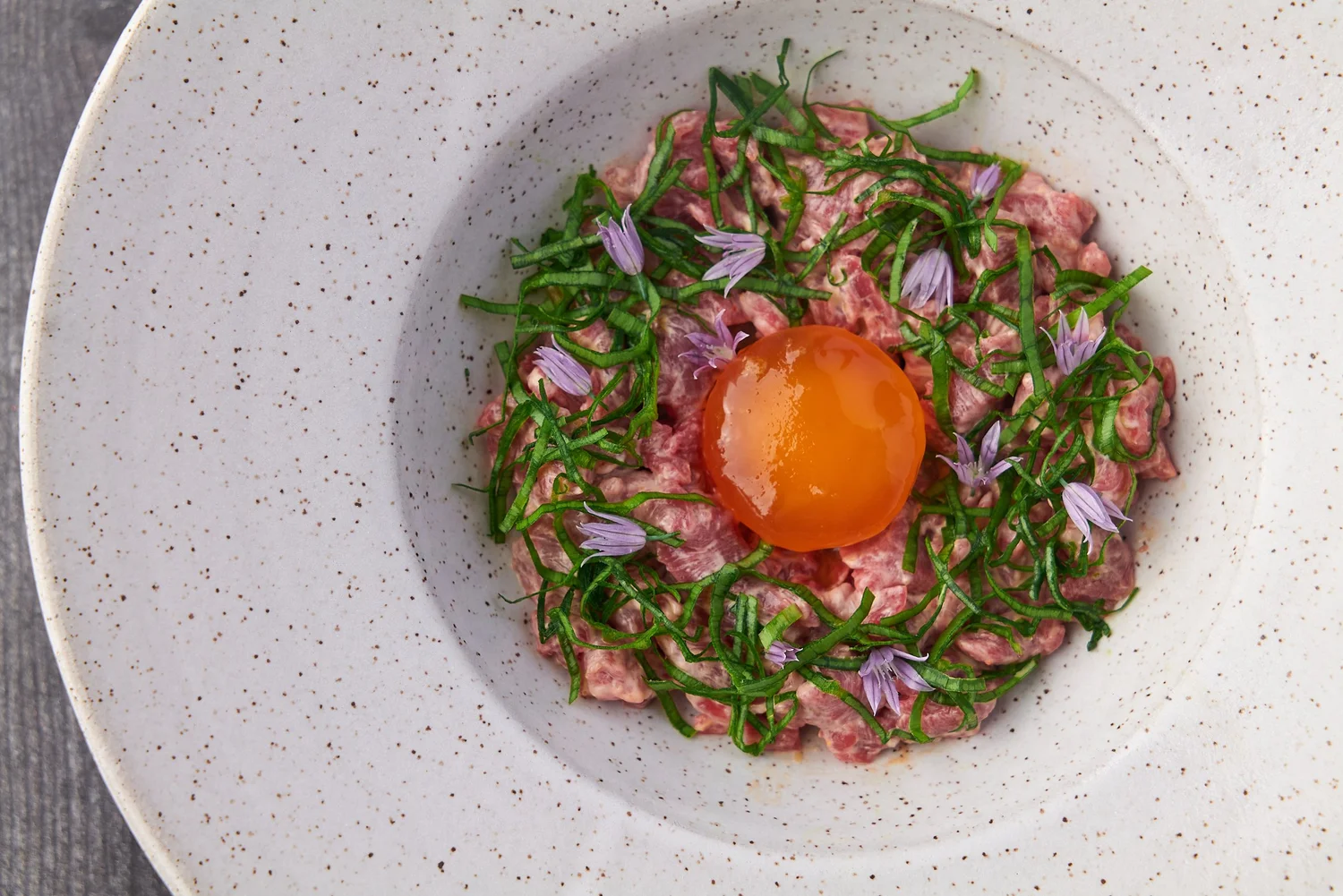 Steak tartare with egg yolk and edible flowers
