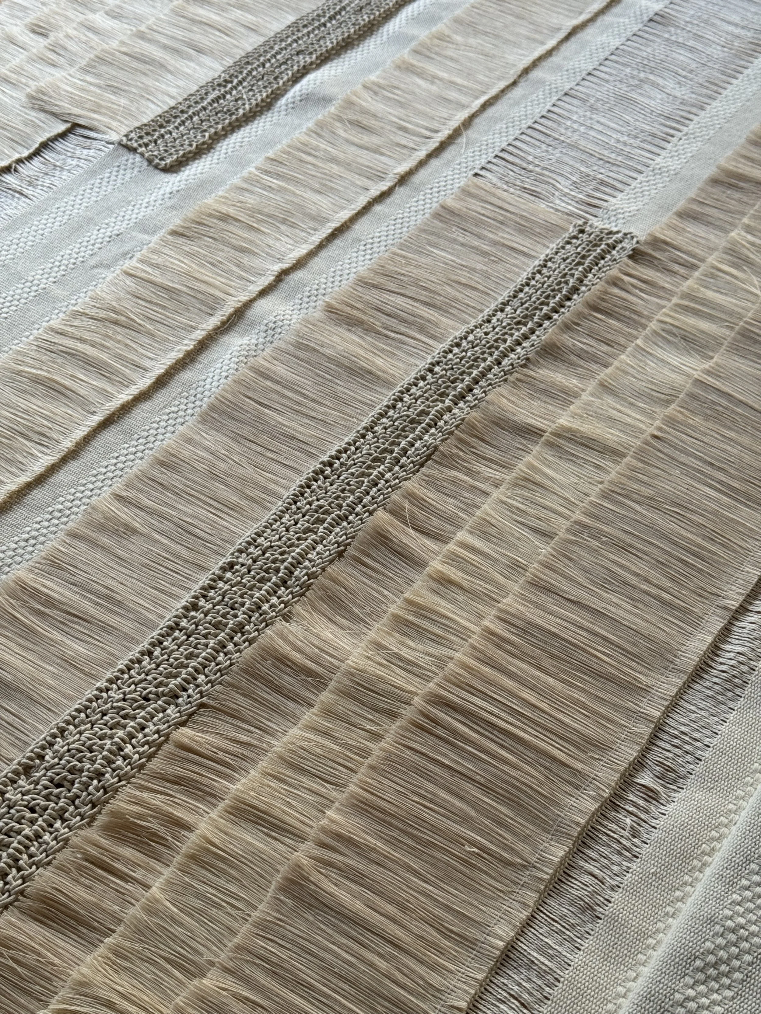 Superficie de madera con diferentes maderas y escobillas de fibras naturales, en tonos claros y beige.