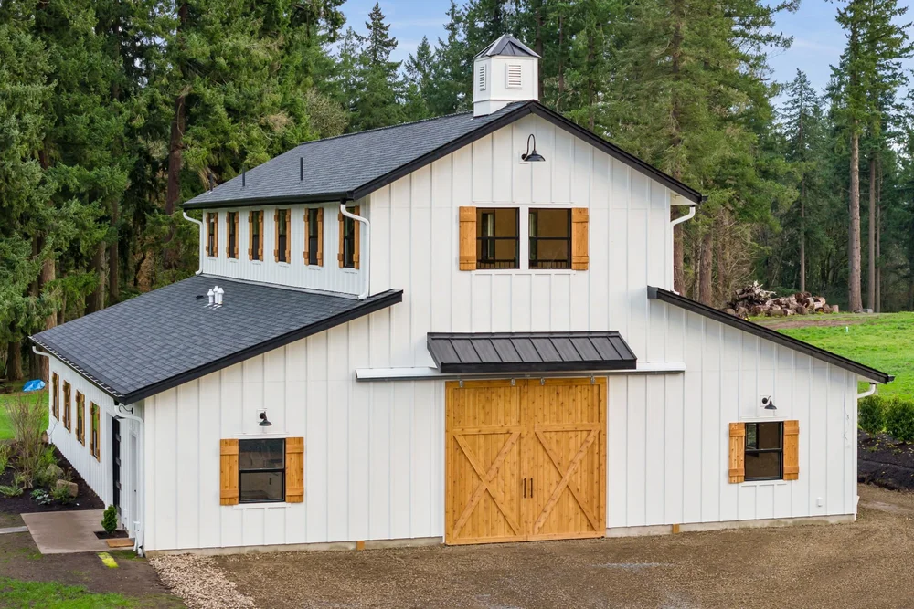 Front exterior showing cedar shutters and doors against white board-and-batten siding.