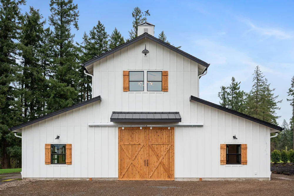 Straight-on view of the barn entrance, cedar shutters, and roof cupola.