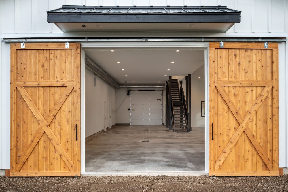 Open wood barn doors framing the main floor and interior staircase.