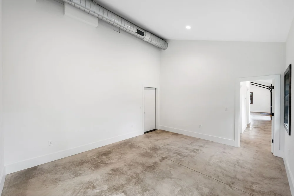 Private room with concrete flooring, white walls, and an open doorway.