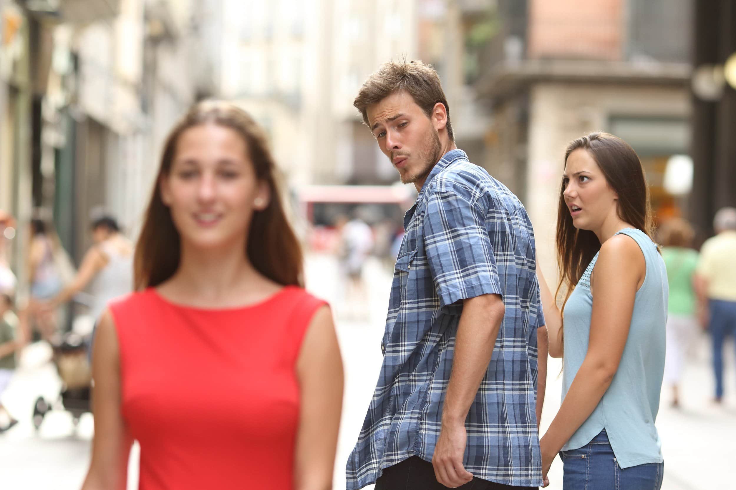 A classic meme of a man checking out a woman on the streetwhile the woman holding his hand looks angry.  In this case, the affronted partner is [Platform 1], and the prospective one was [Platform 2].