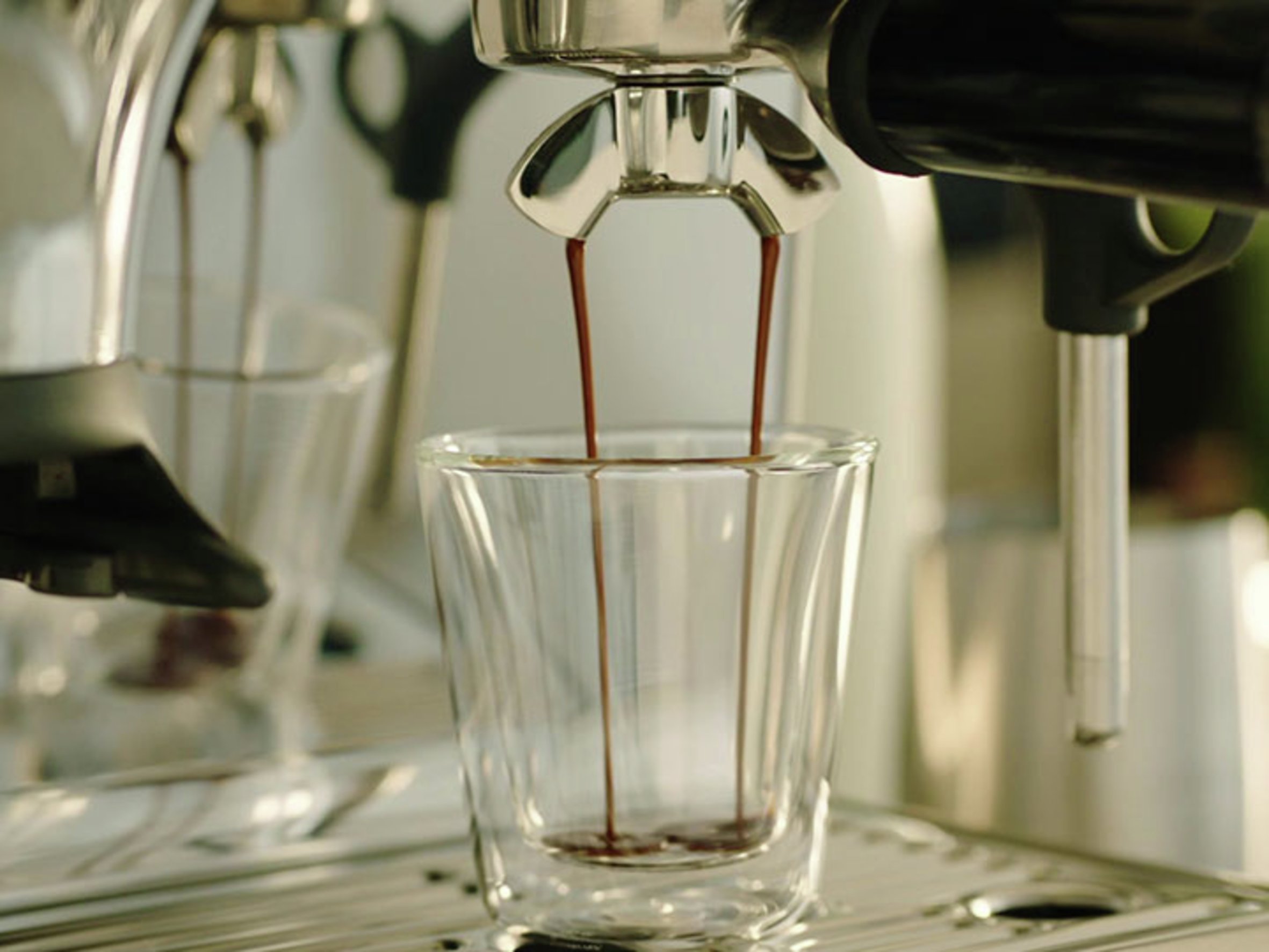 image of espresso flowing out of portafilter into glass