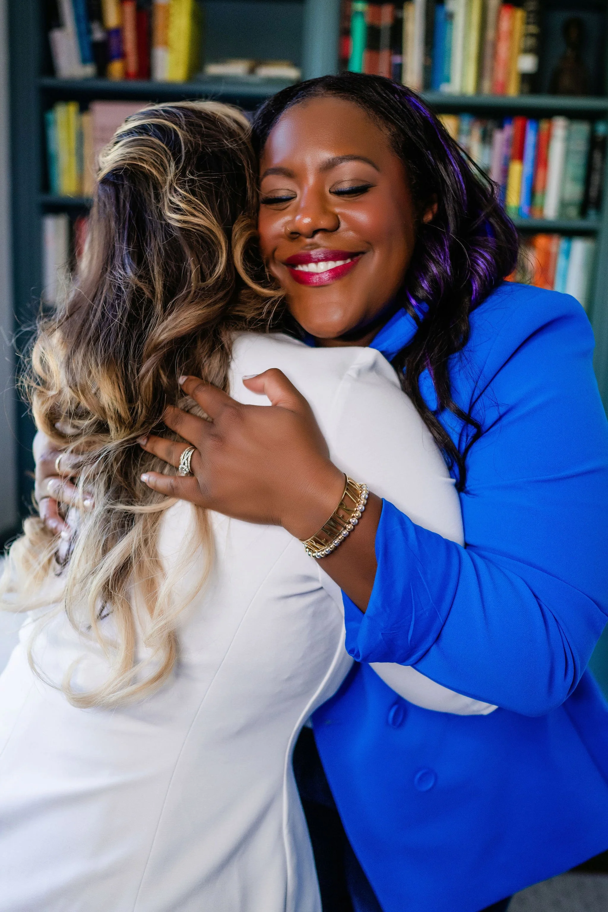 Hannah Wachter smiling mid-hug with a client, a moment of warmth and connection