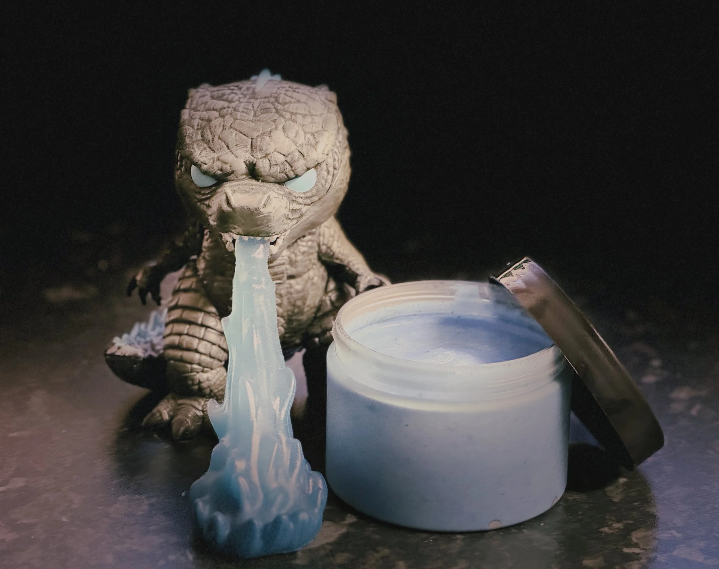 Godzilla funko pop next to a tub of atomic blue heat ray ice cream.