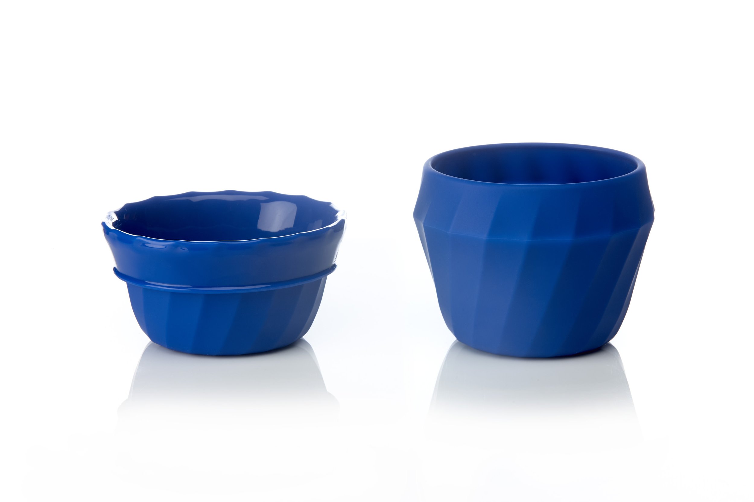 Two blue ceramic bowls, one smaller with a scalloped edge and one larger with a faceted design, on a white background.