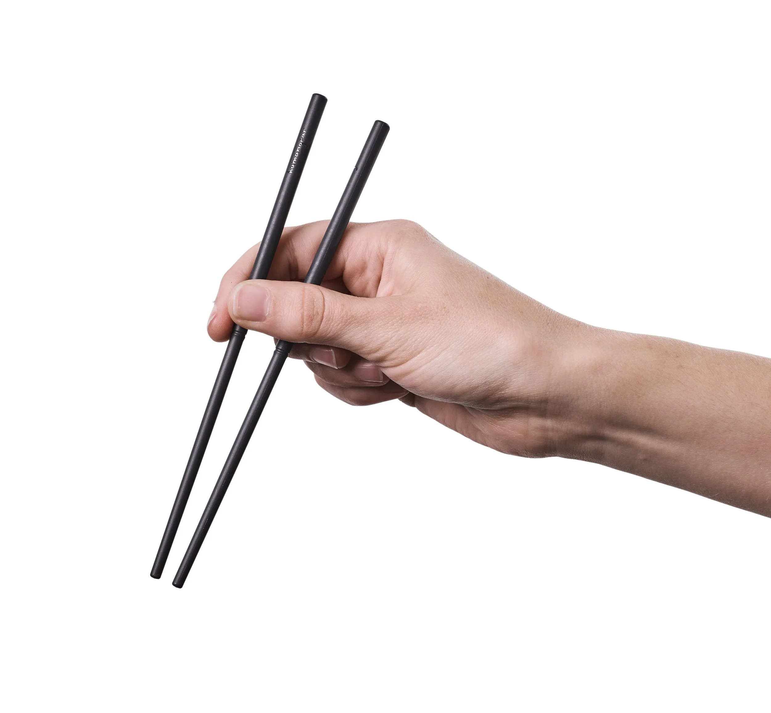 Hand holding black chopsticks against a white background.