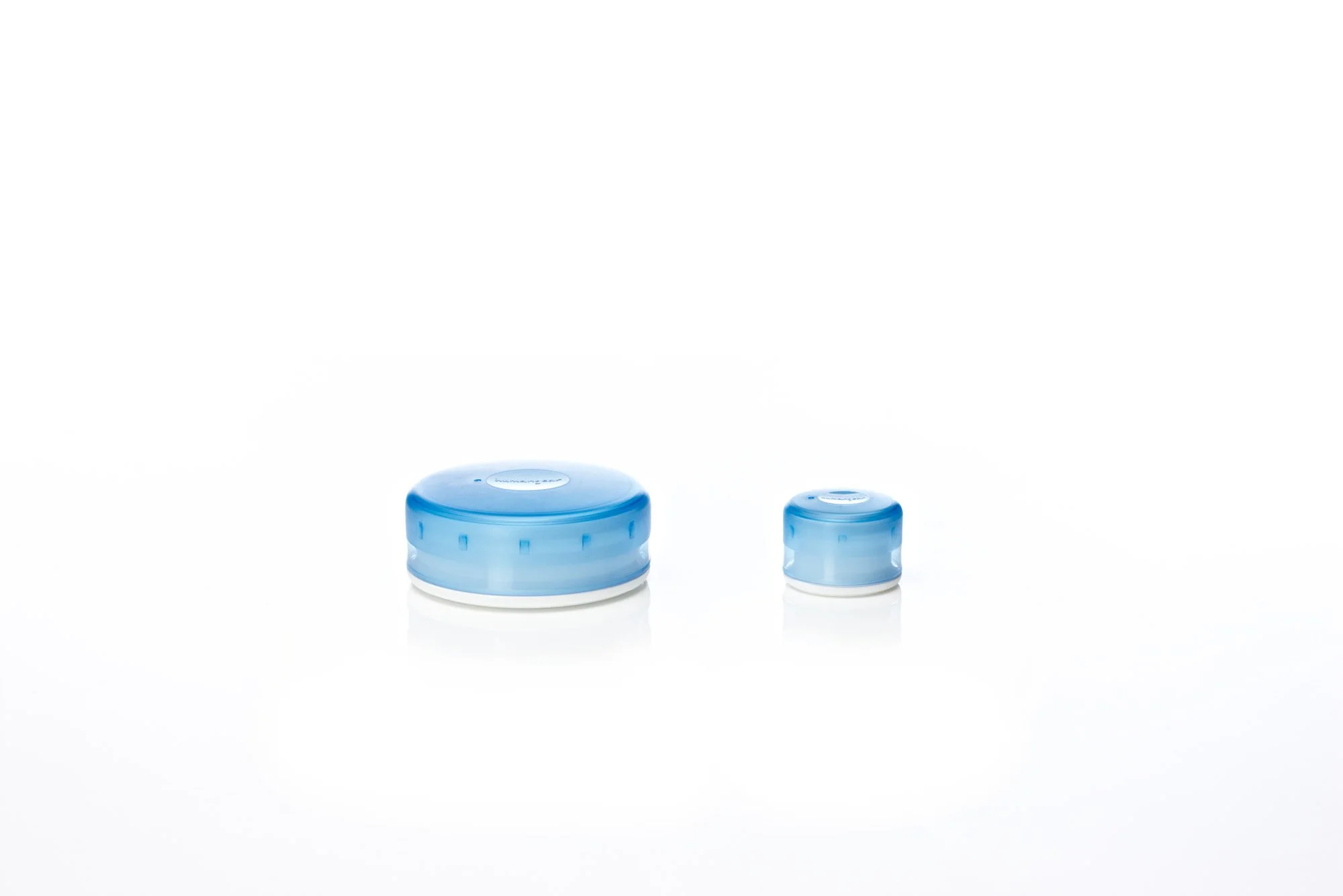 Blue jar lids, one large and one small, on a white background.