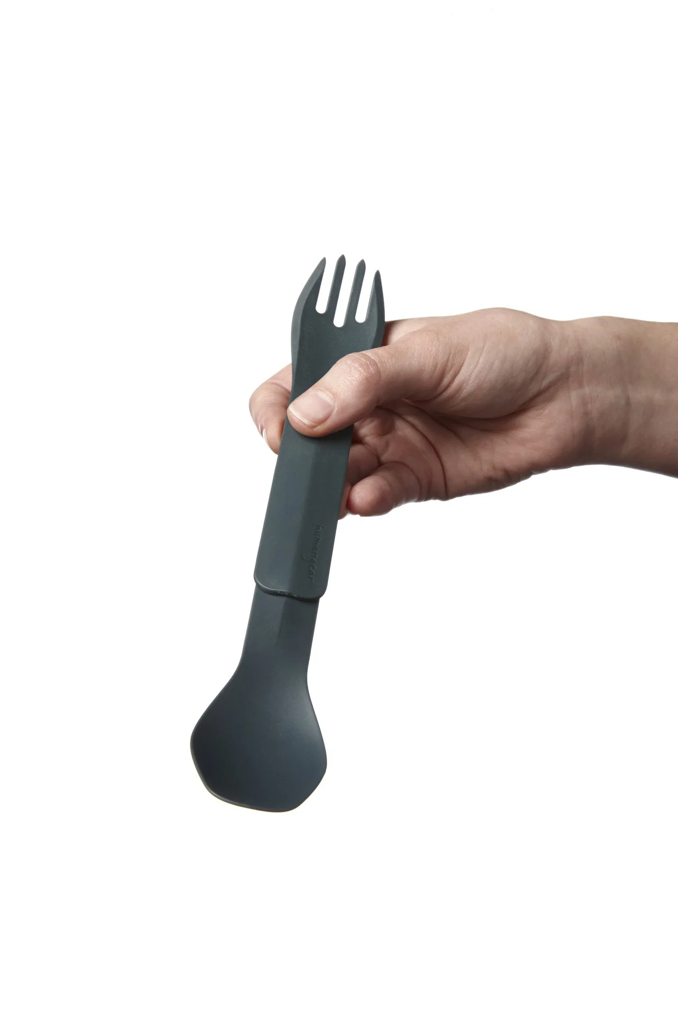 A hand holding a dark gray spork with a spoon on one end and fork on the other.