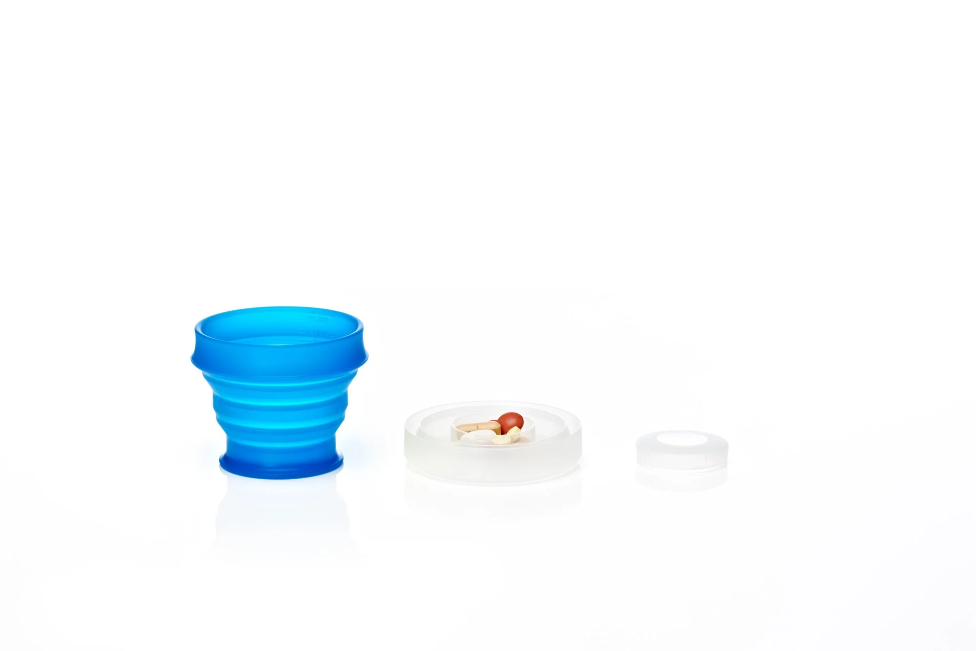 Collapsible blue cup with container and pills