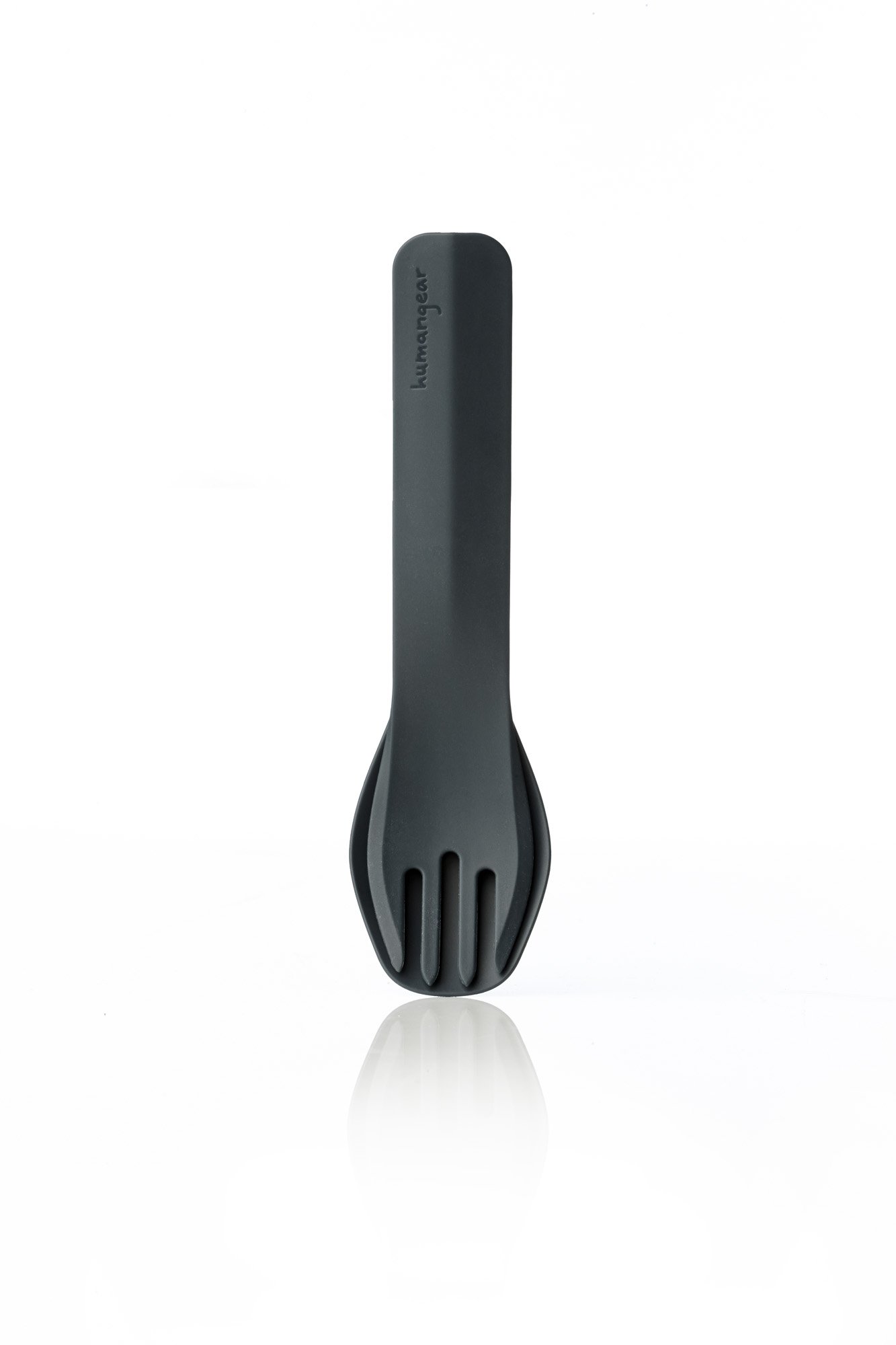 Black spork standing upright on a reflective surface against a white background.