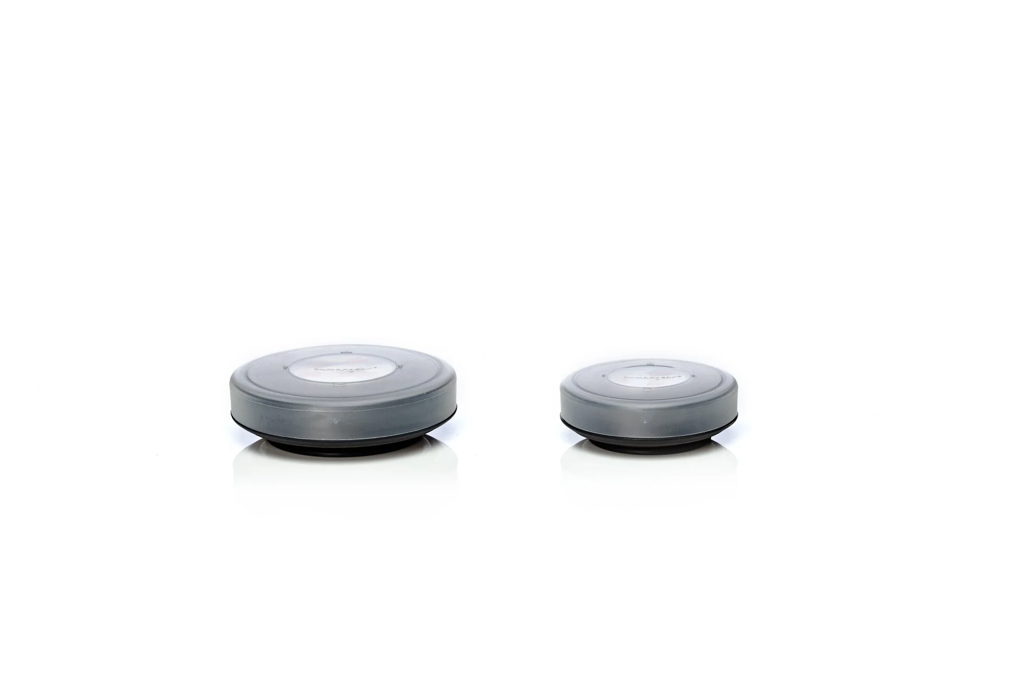Two round, gray containers with lids, one larger than the other, on a white background.
