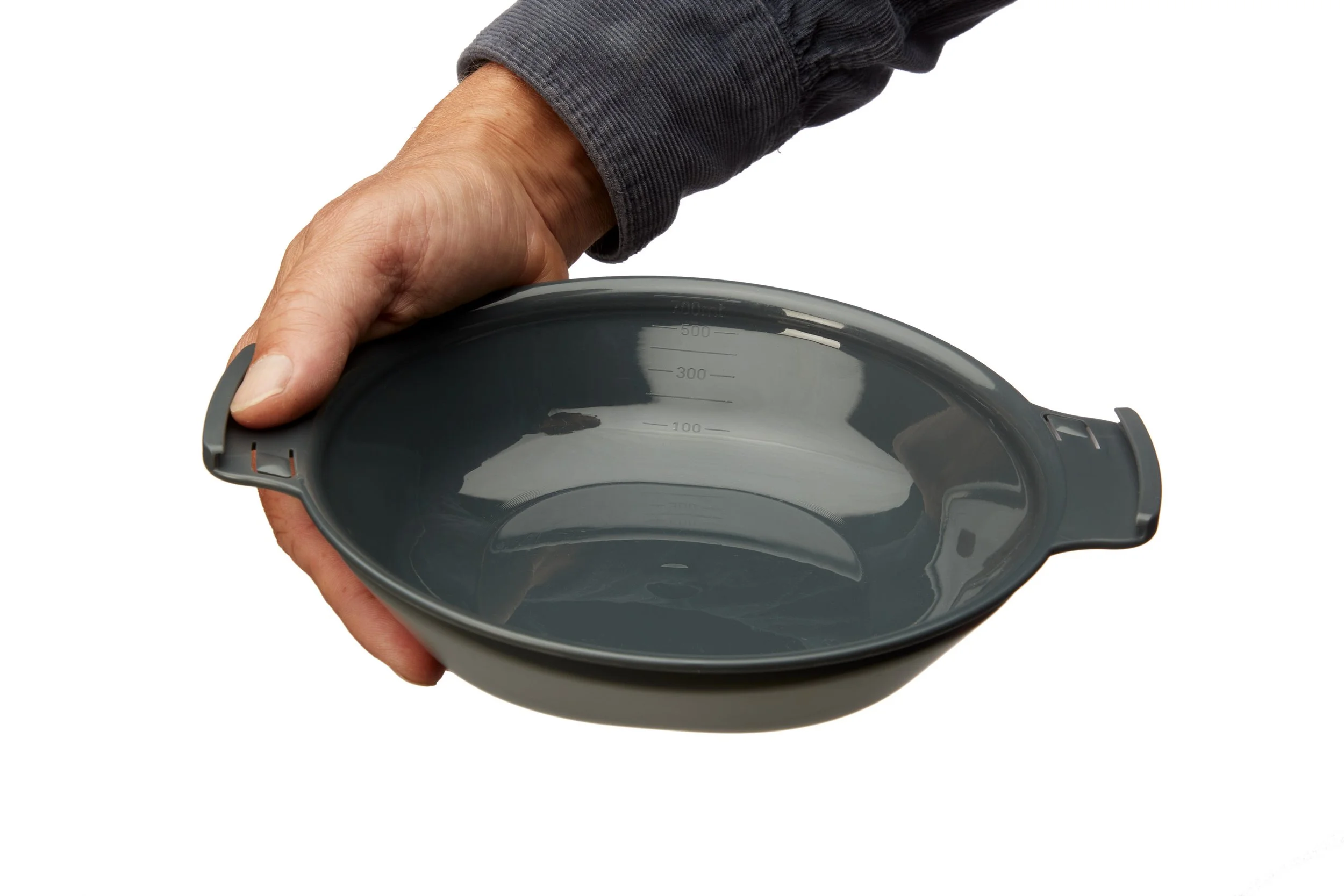 Person holding a gray measuring bowl with handles and volume markings on the inside.