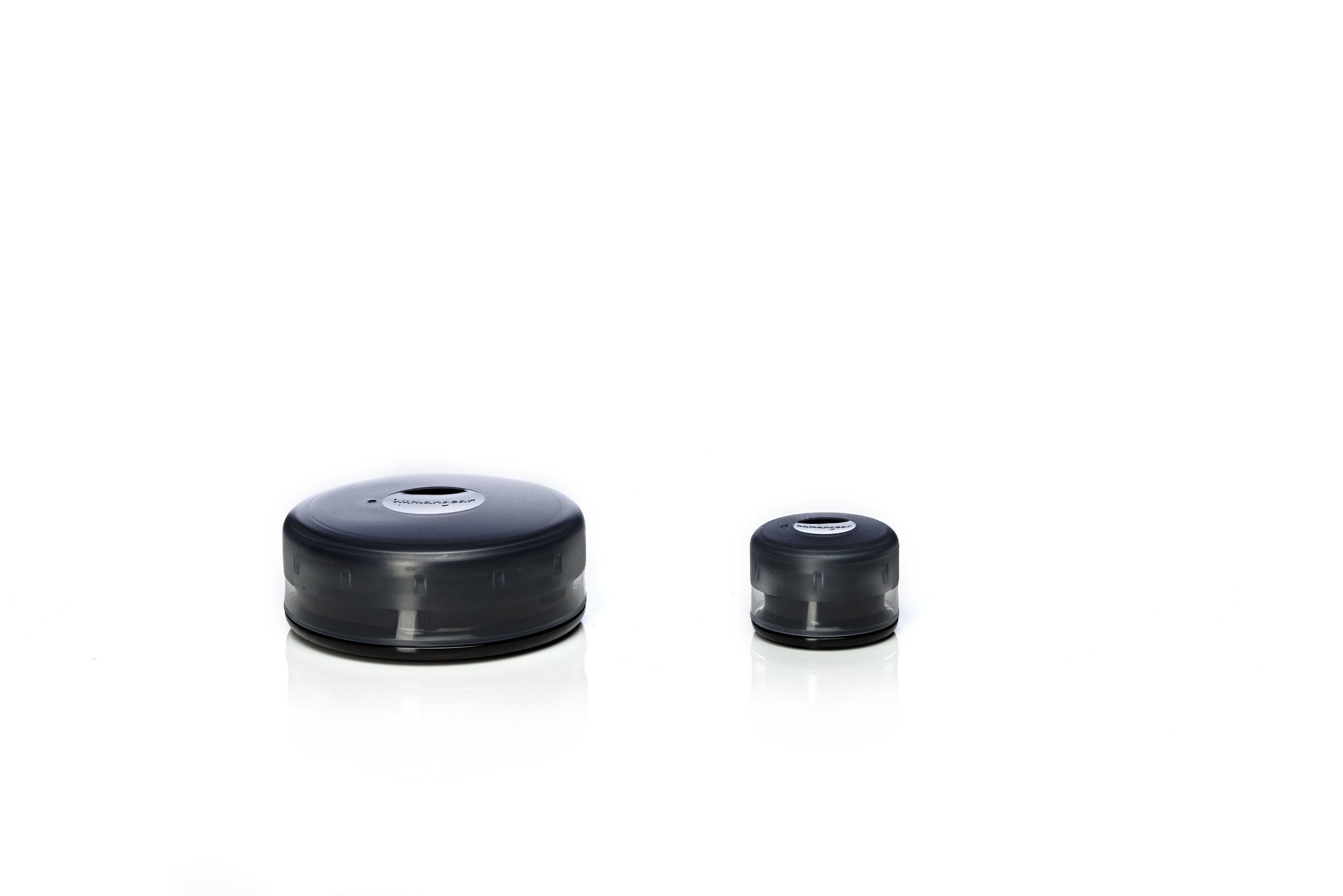 Two black, round water filters of different sizes on a white background.