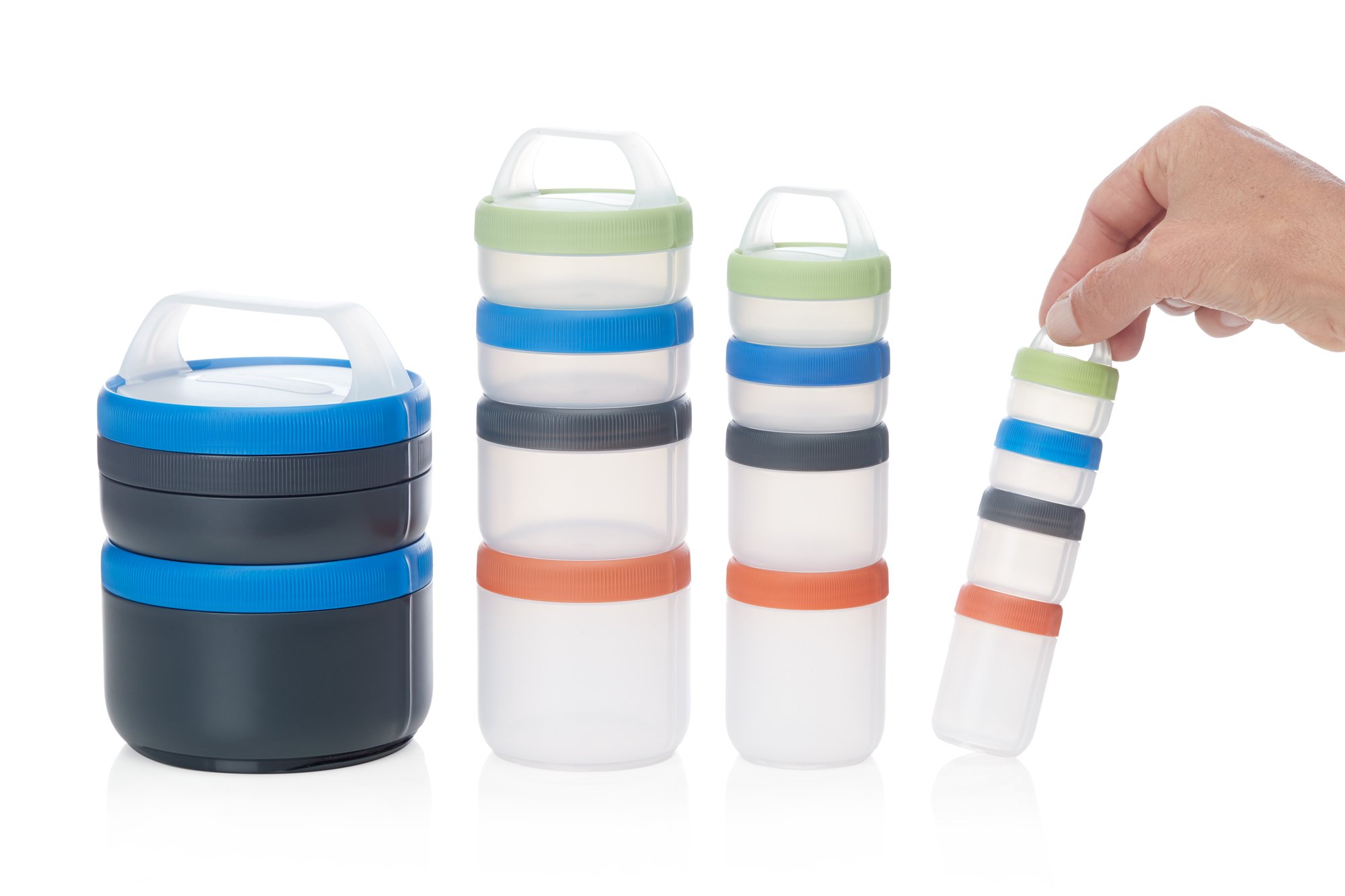 A hand holding stacked small plastic containers with colorful lids and handles, alongside larger stacked containers with different colored lids, on a white background.
