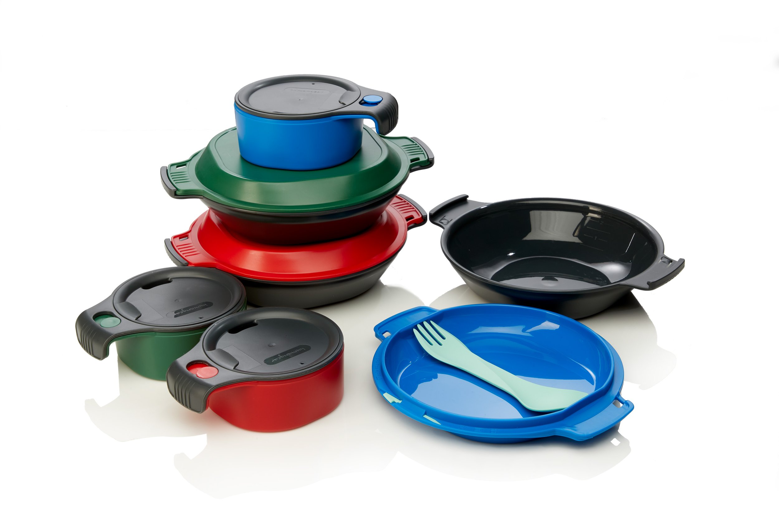 A set of colorful plastic camping dishes, including bowls, plates, and stacking cups with lids, displayed against a white background. A green spork is placed on a blue plate.