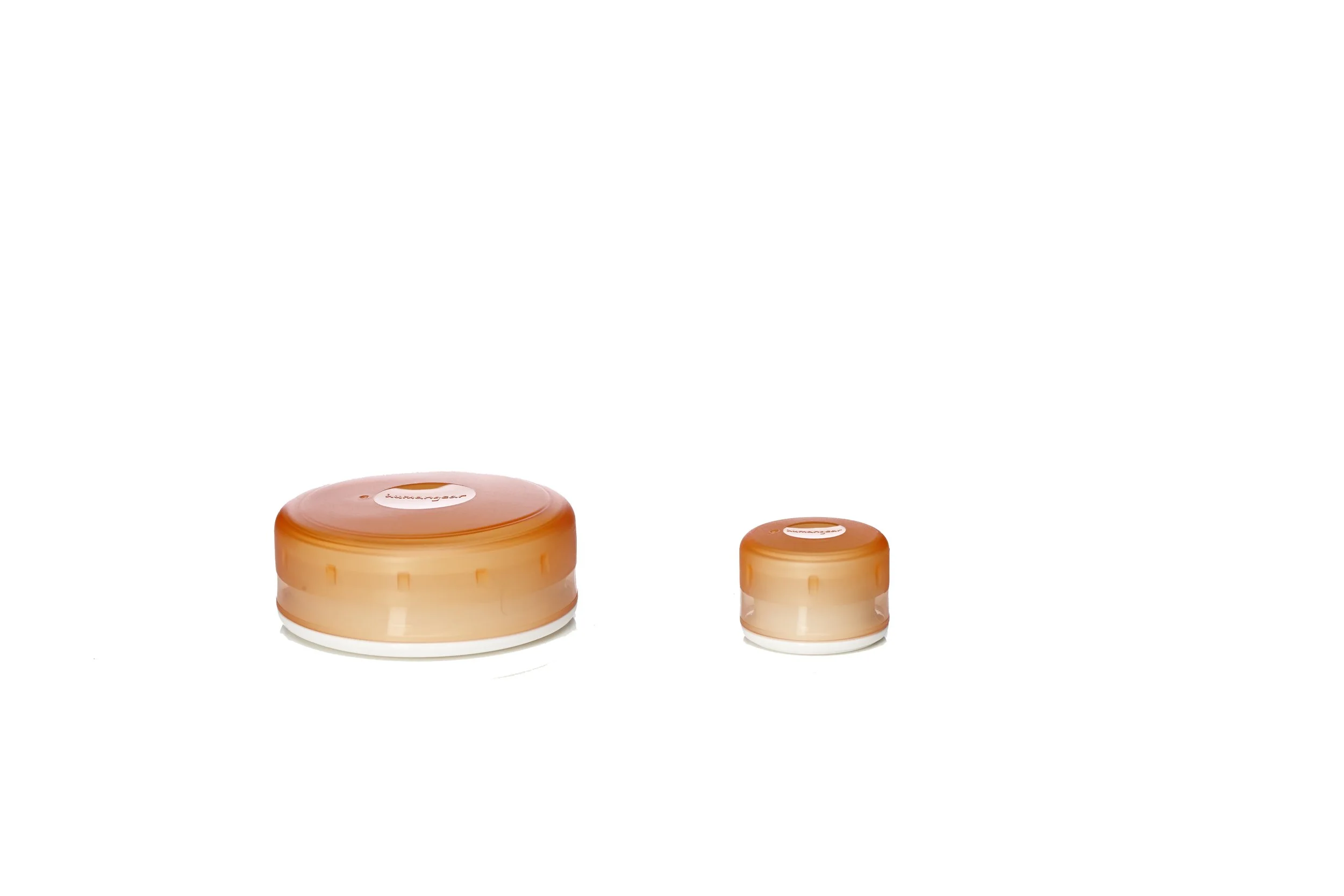 Two round, orange and beige containers with labels on top, varying in size, placed on a white background.