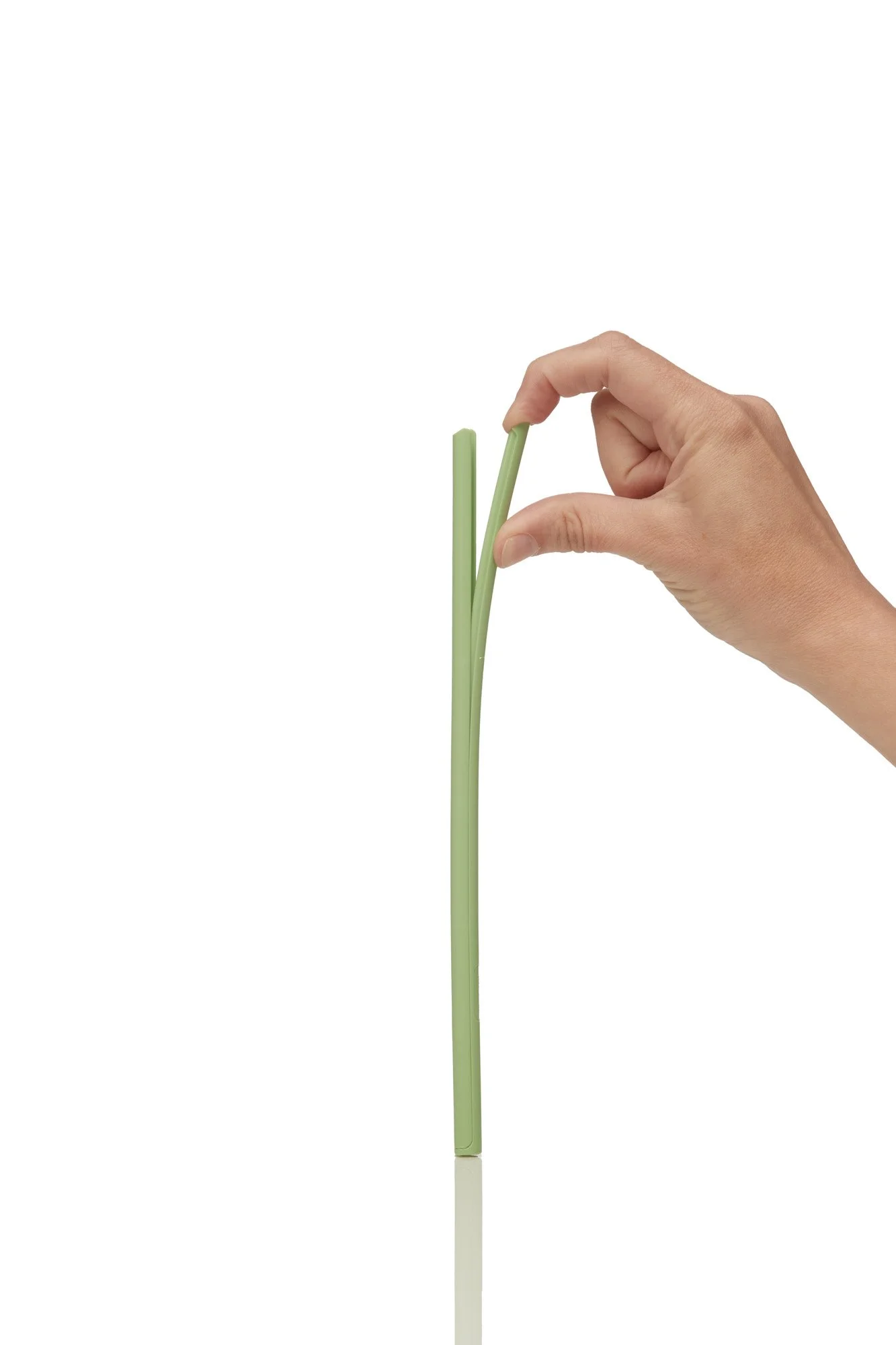 hand breaking a green stick against a white background