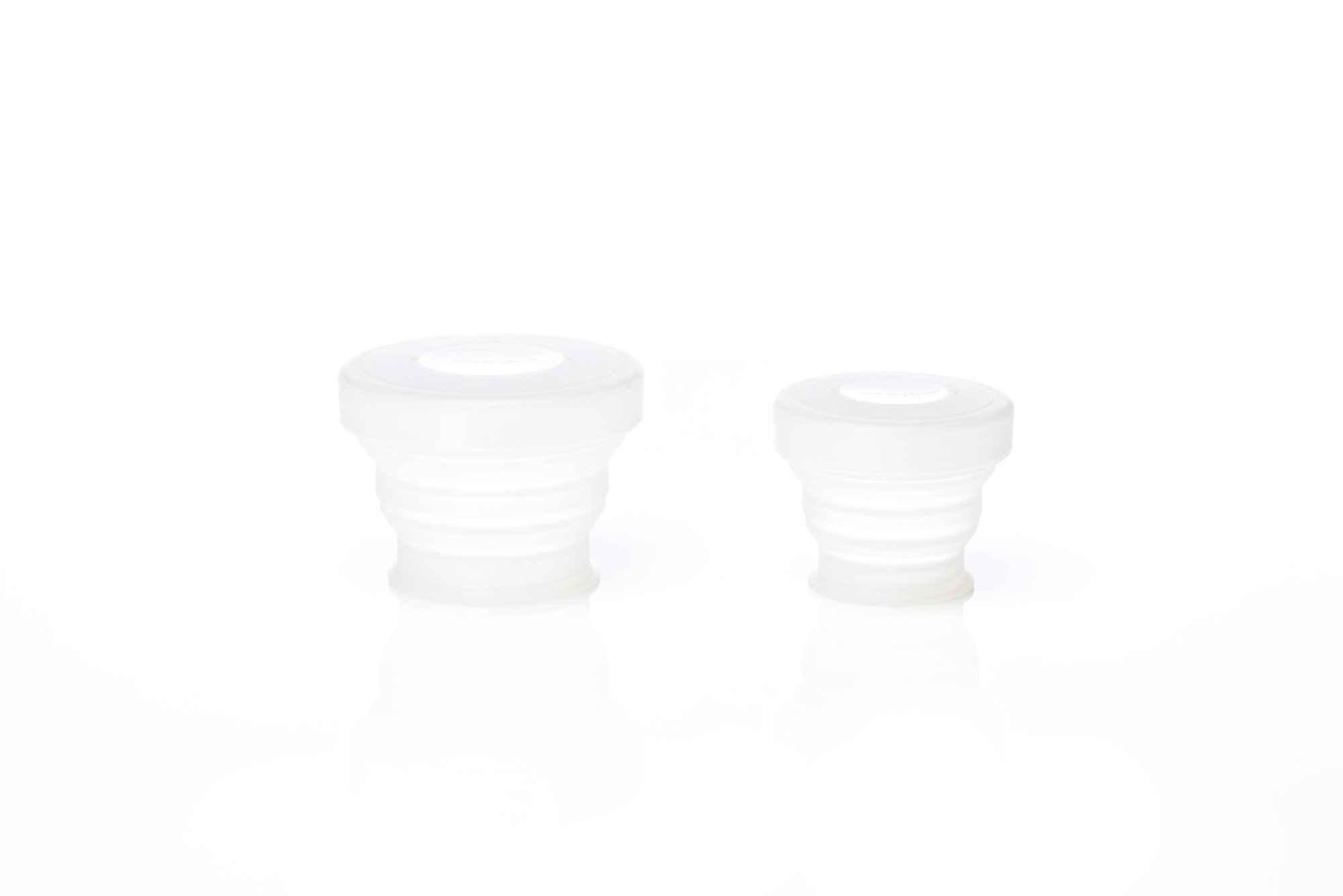 Two white silicone cup covers, one larger and one smaller, isolated on a white background.