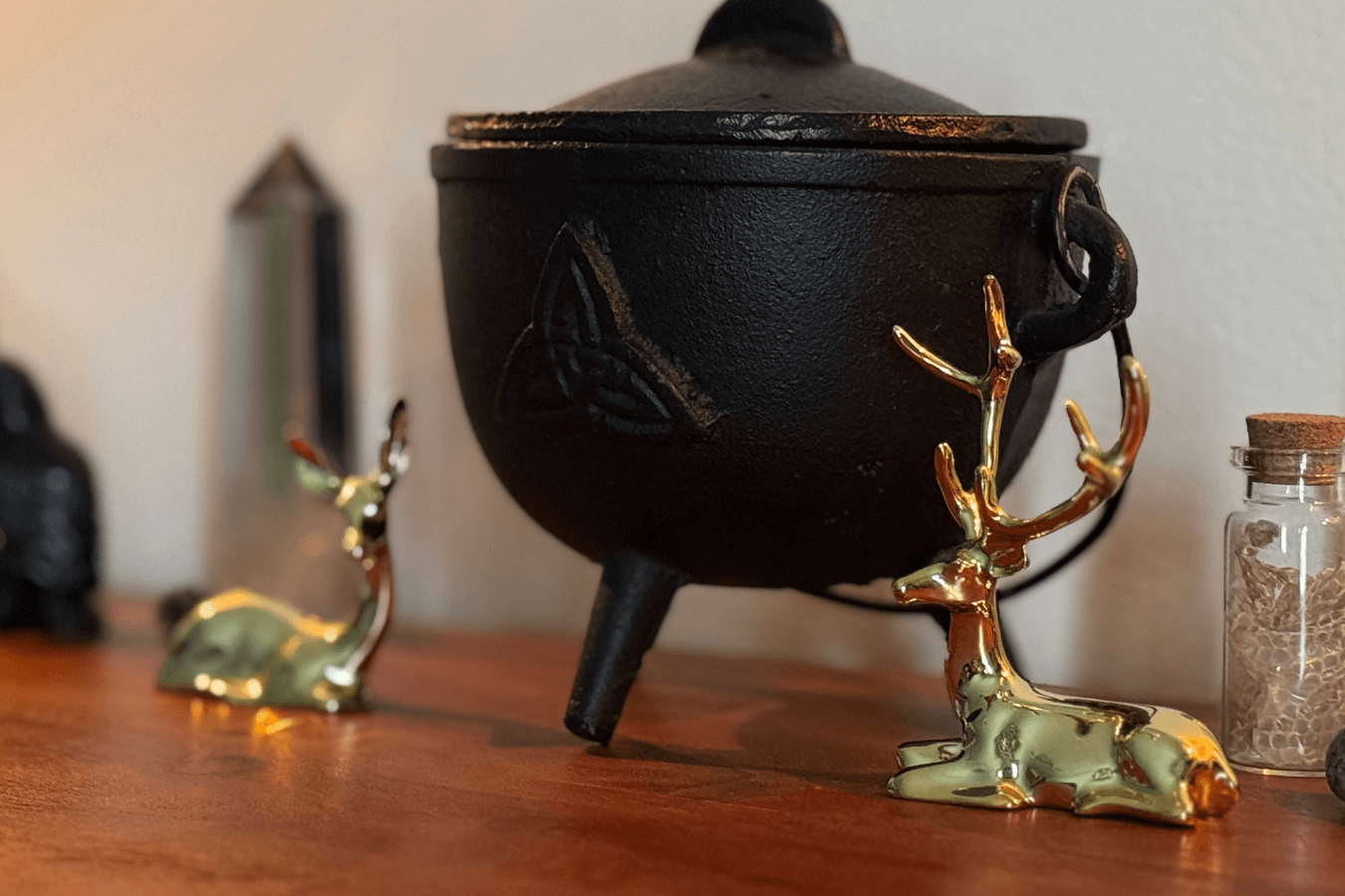 a photo of a Celtic cauldron and two golden deer statues on either side
