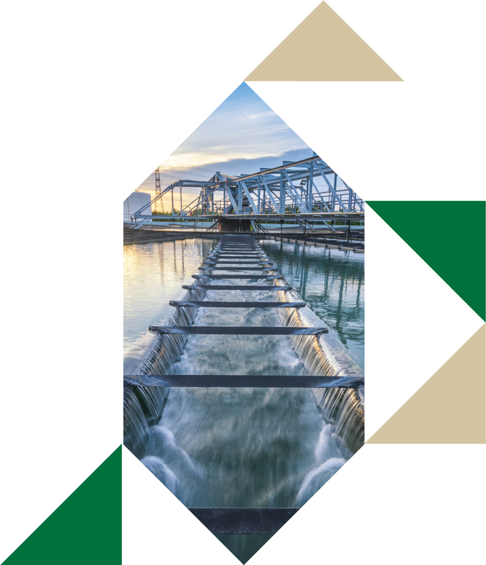 Dam with water flowing over spillway at sunset