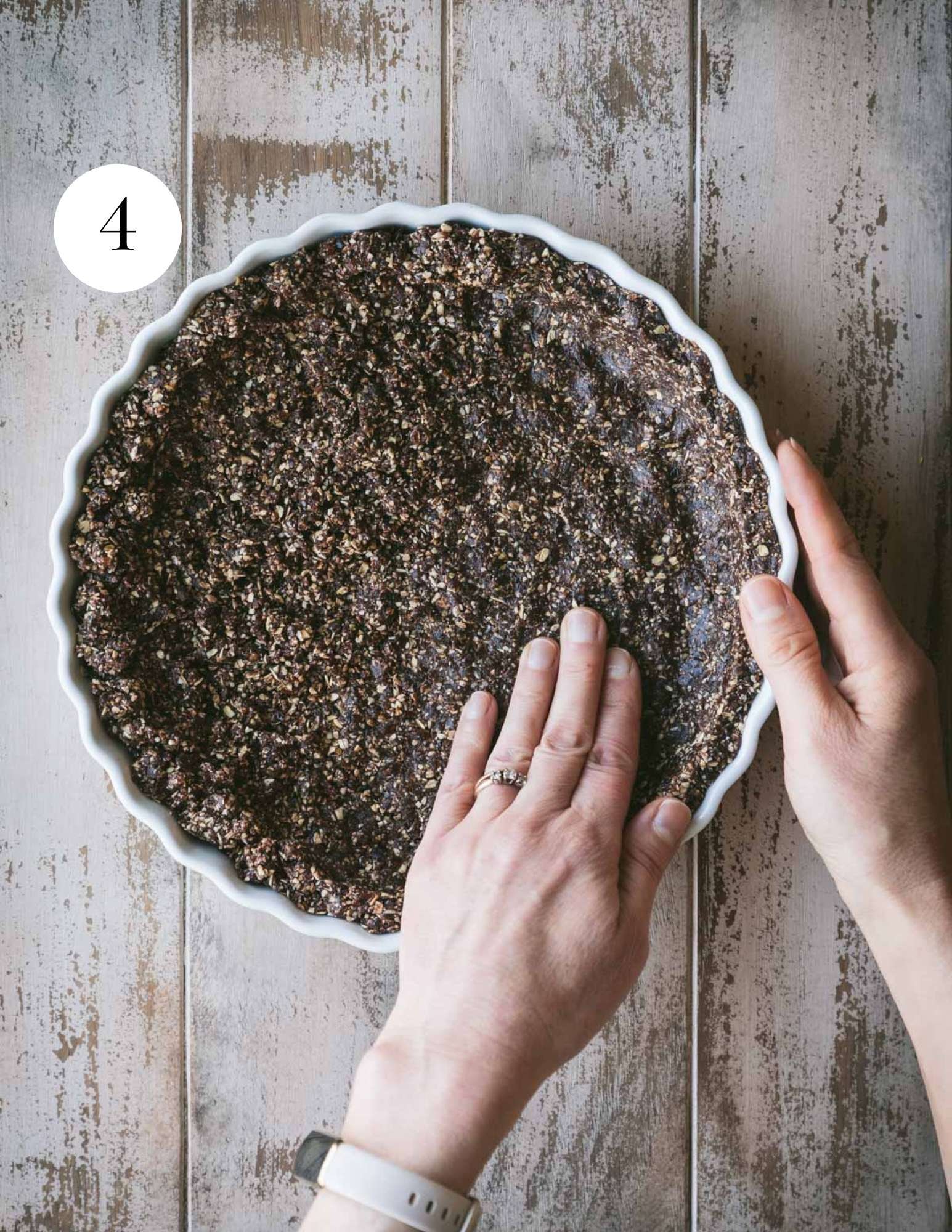 Pressing the crust into a tart pan by hand.