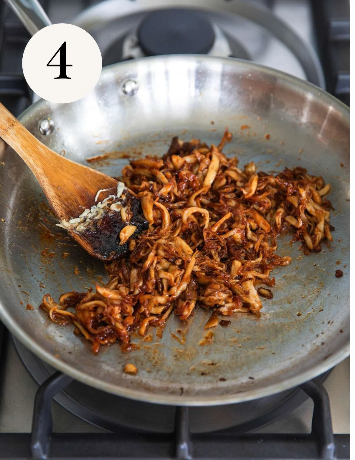 BBQ sauce on vegan pulled mushrooms in a pan.