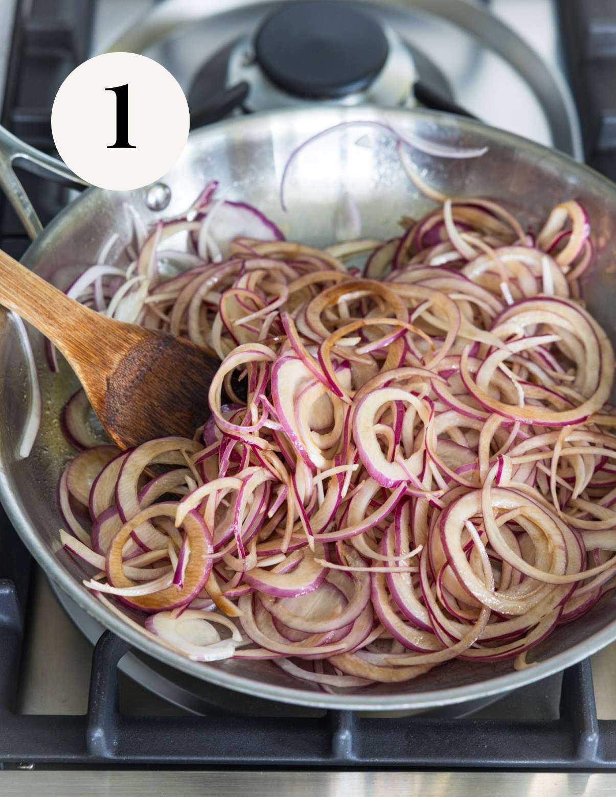 sliced red onions in a pan