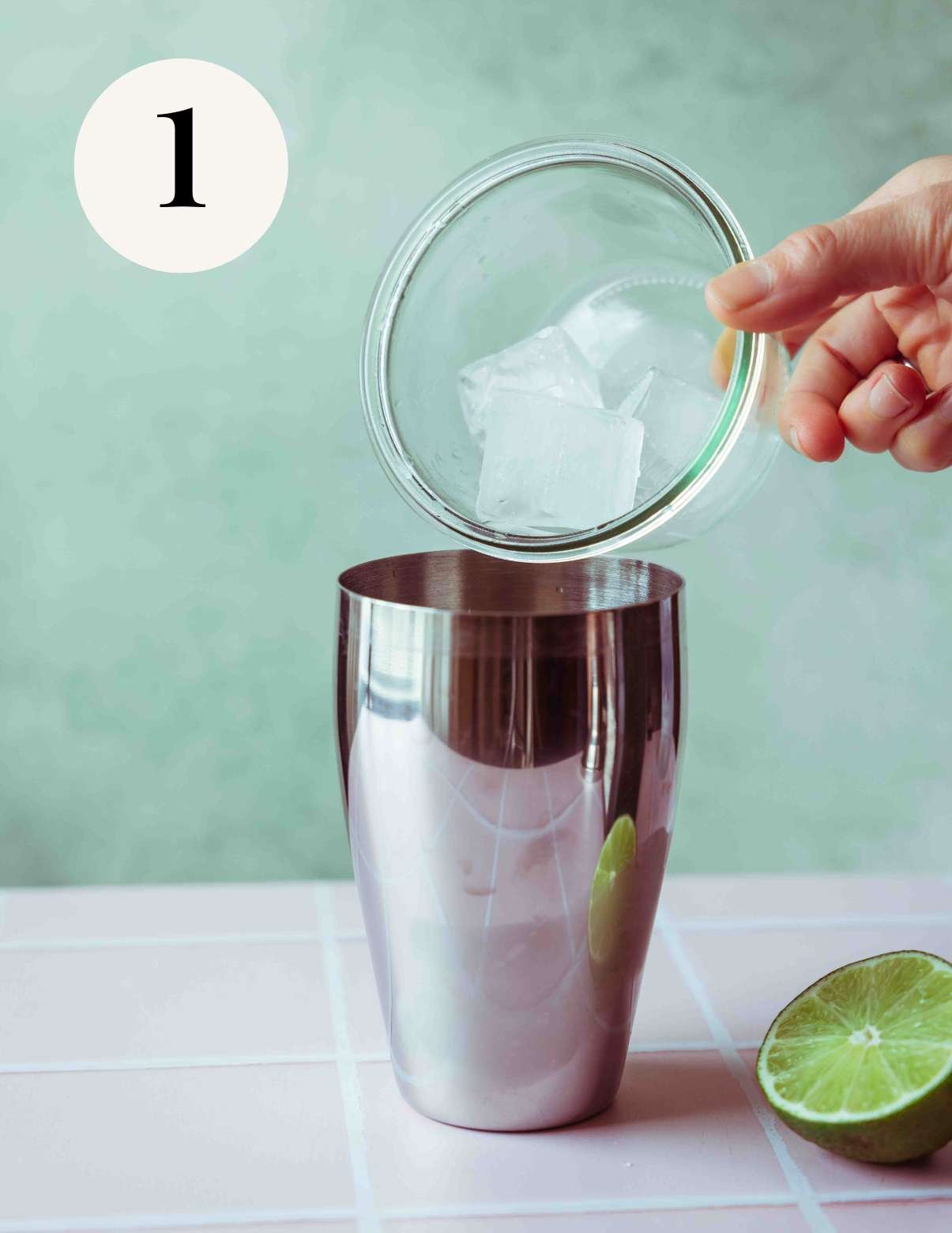 adding ice cubes to a cocktail shaker