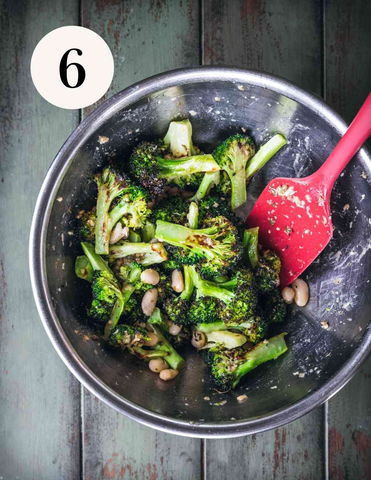mixing broccoli caesar salad in a bowl