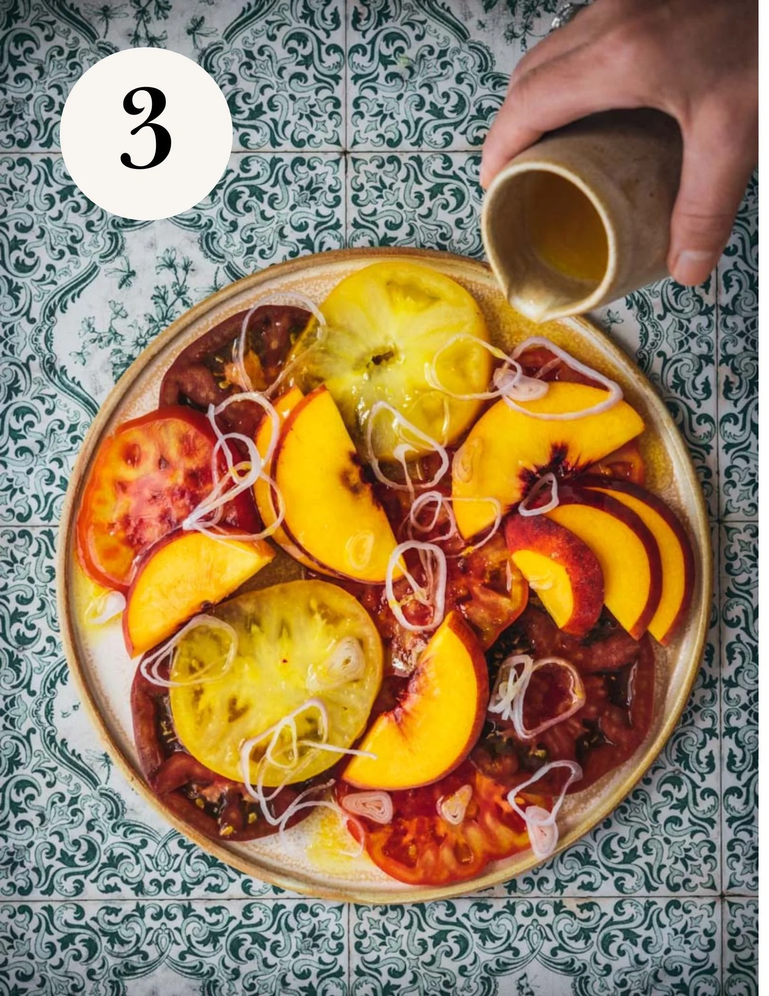 pouring orange vinaigrette over tomato crudo