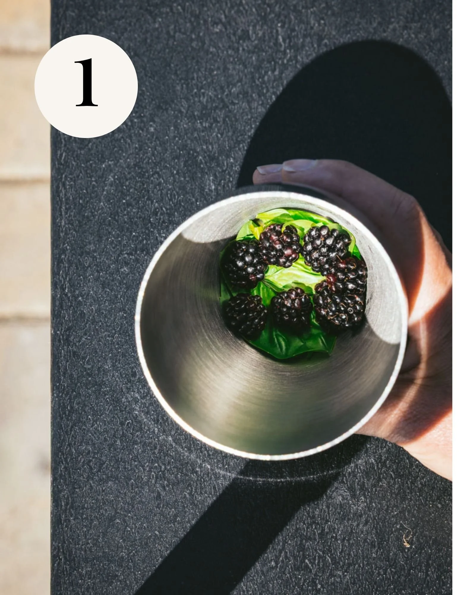basil leaves and blackberries in a cocktail shaker