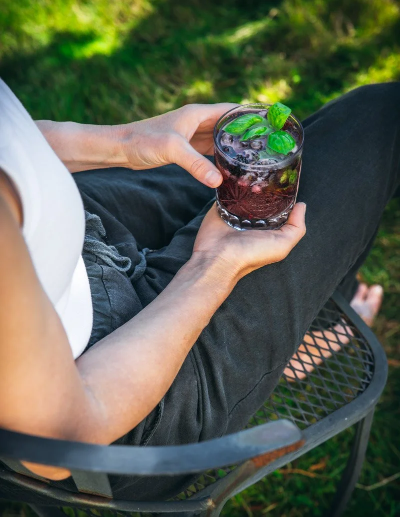Carol holding a blackberry smash outside