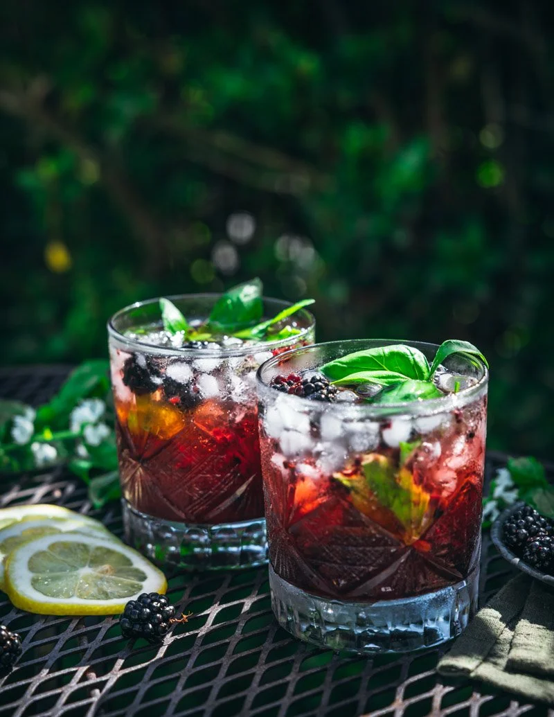 blackberry smash vodka cocktail with fresh basil leaves