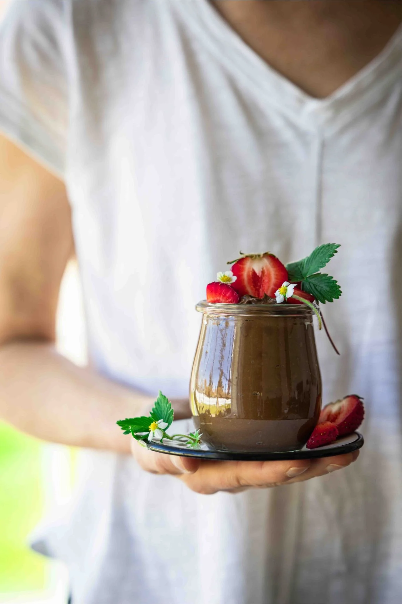 Carol holding a pot of vegan avocado chocolate mousse