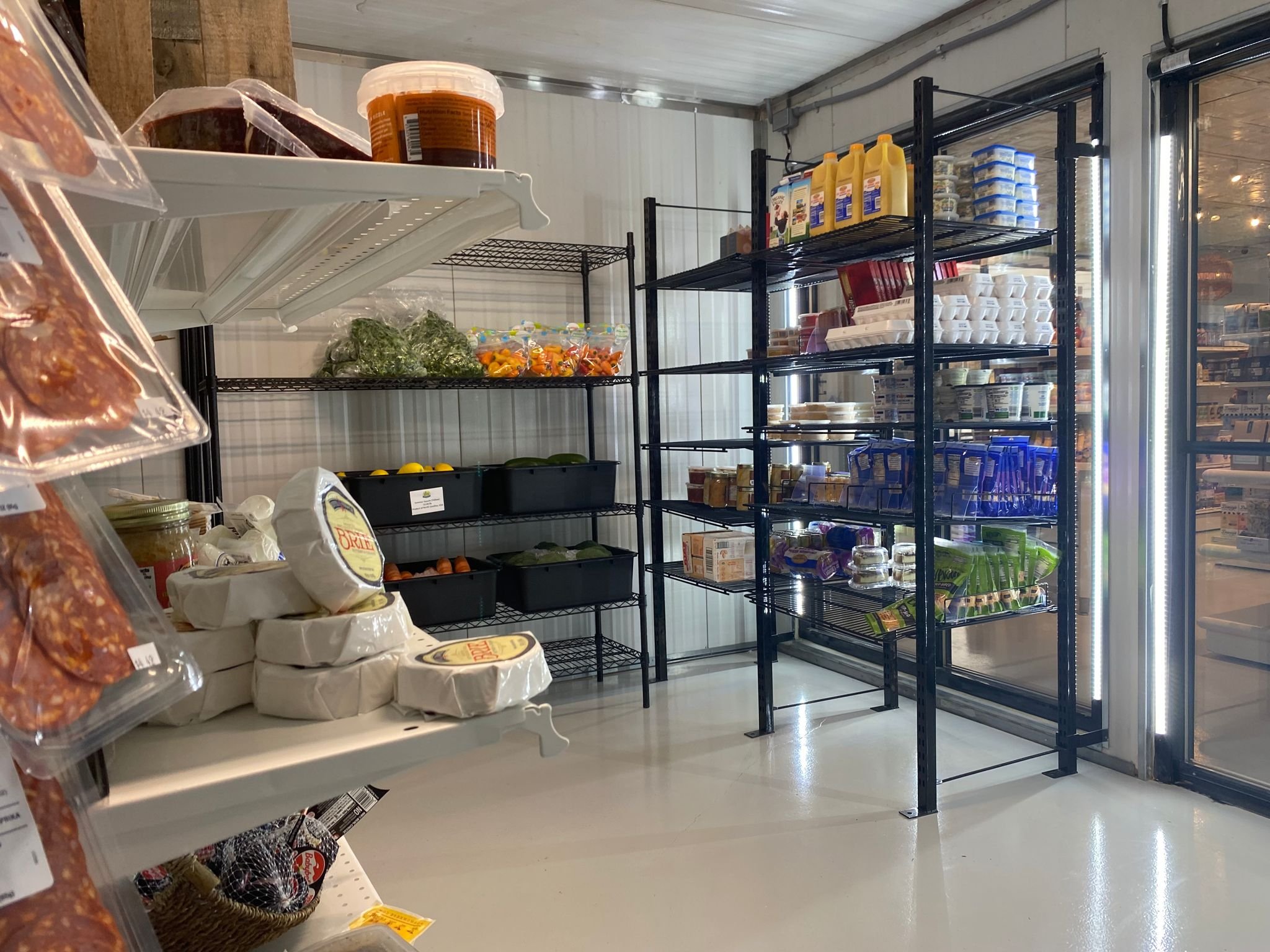 Walk-in fridge with produce, cheeses, craft beer, and more