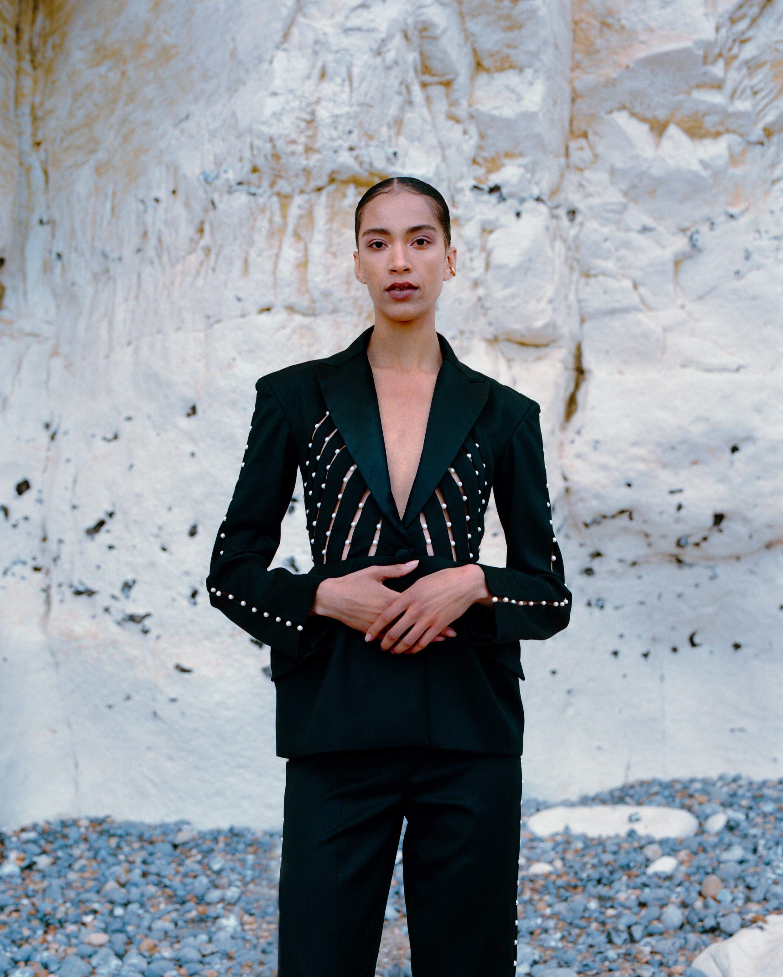 mixed race woman wearing a black tuxedo with pearl details
